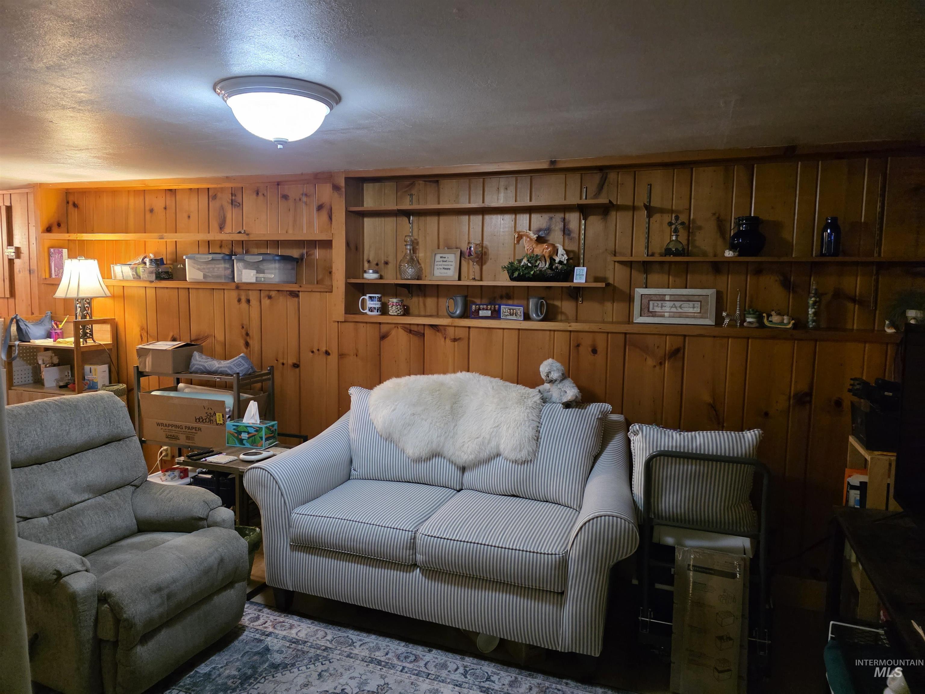 Living area with a textured ceiling and wood walls