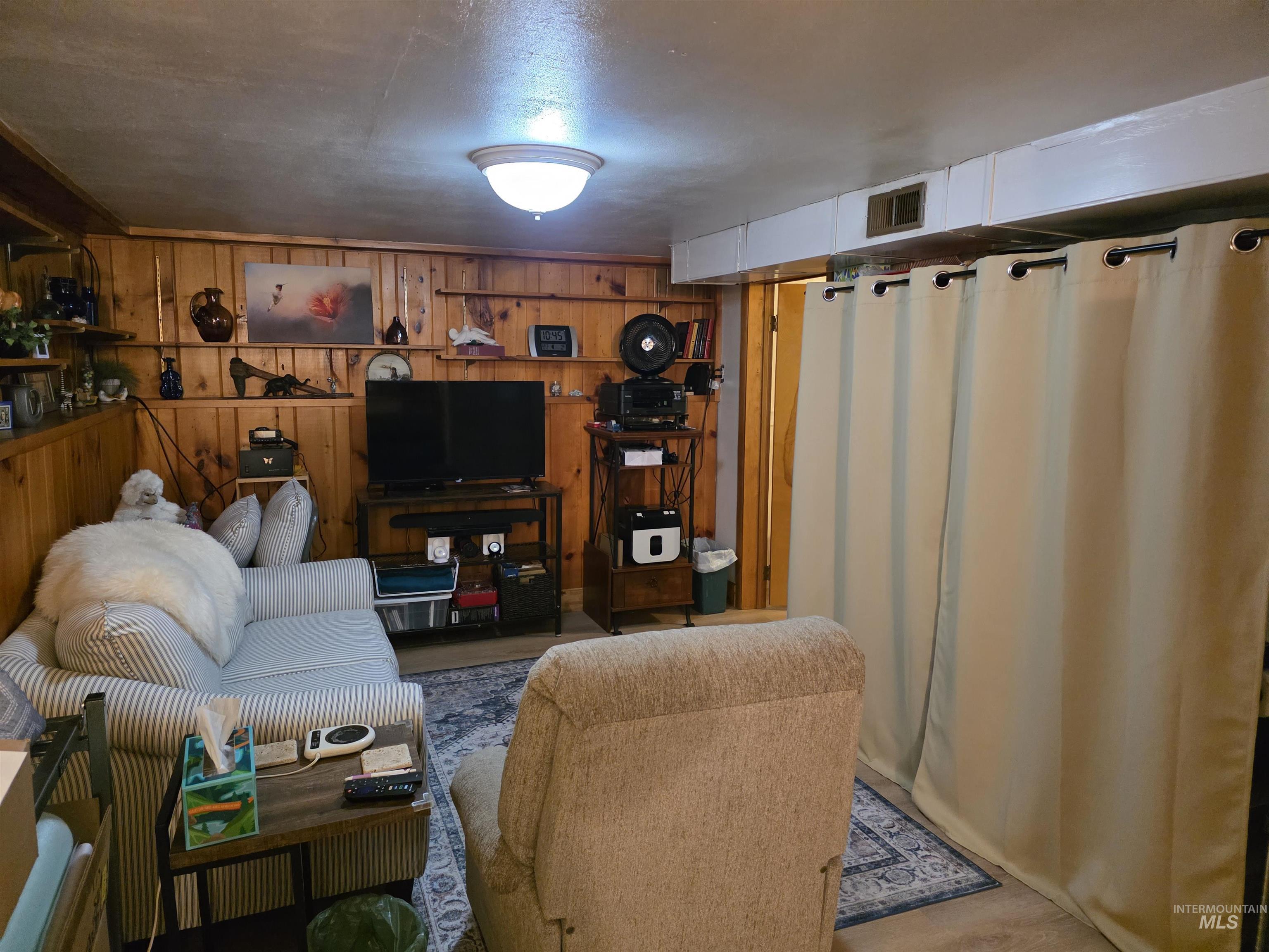 Living area featuring wooden walls
