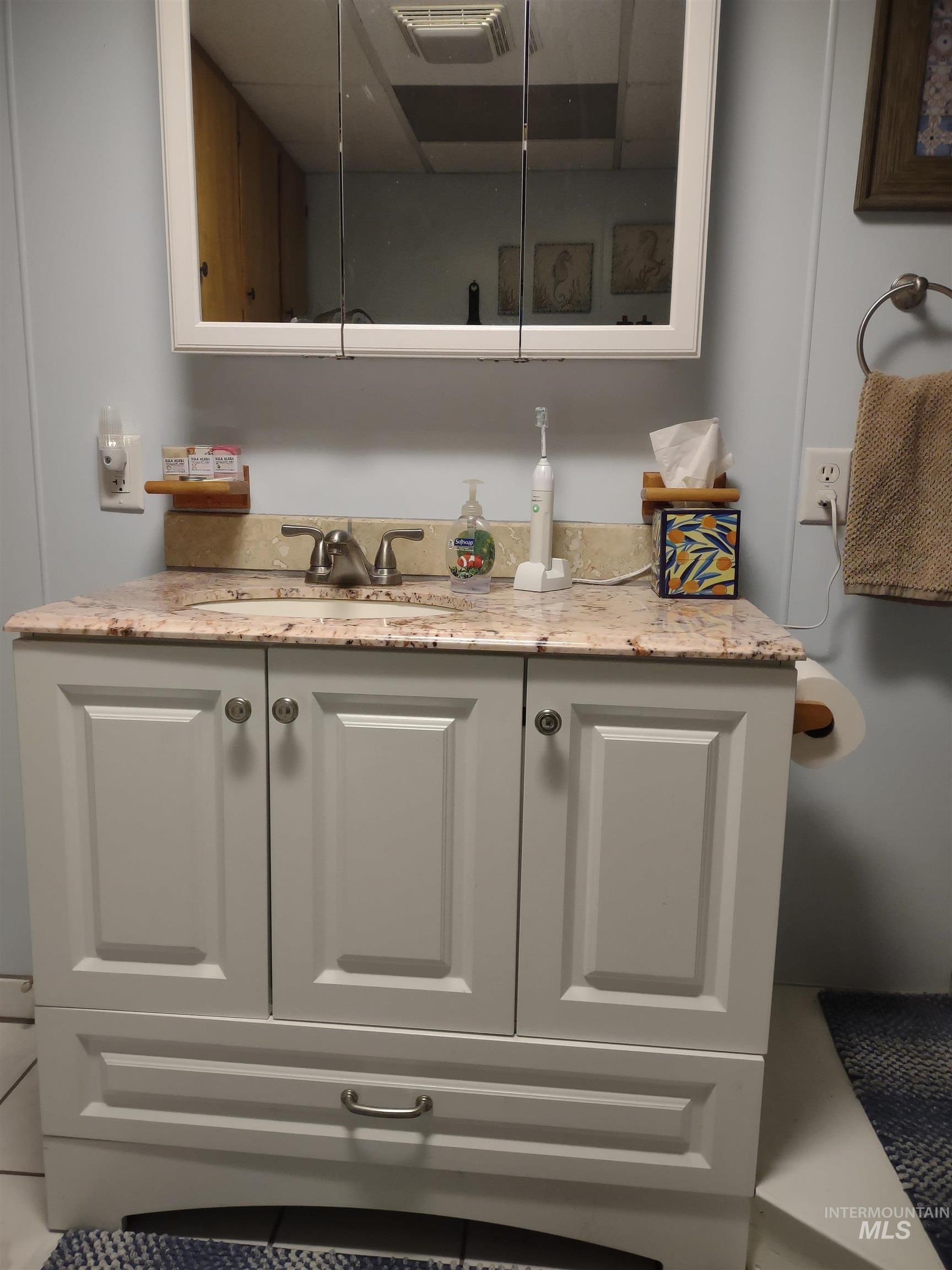 Bar with light stone countertops and white cabinetry