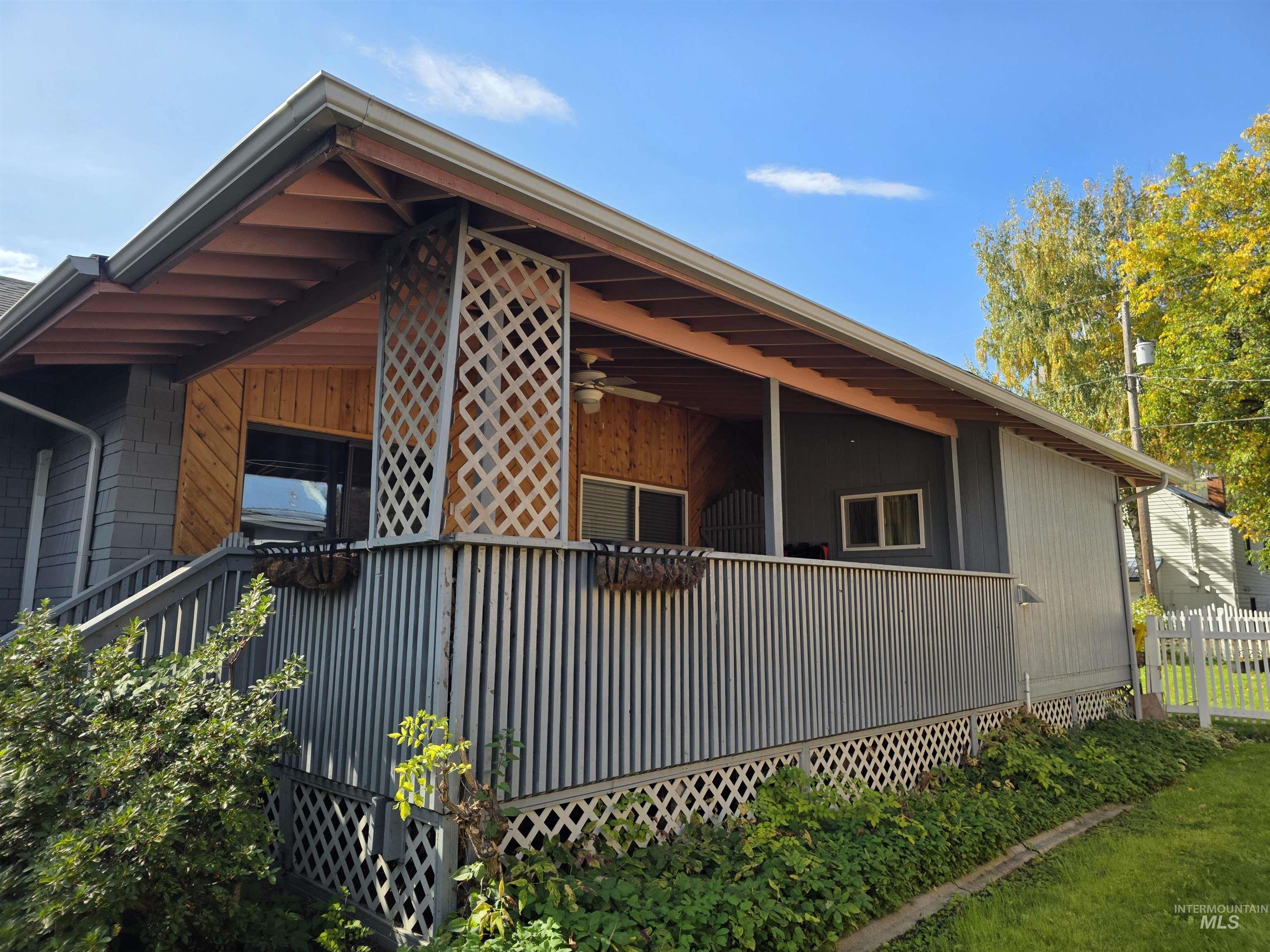 View of side of property featuring a deck and ceiling fan