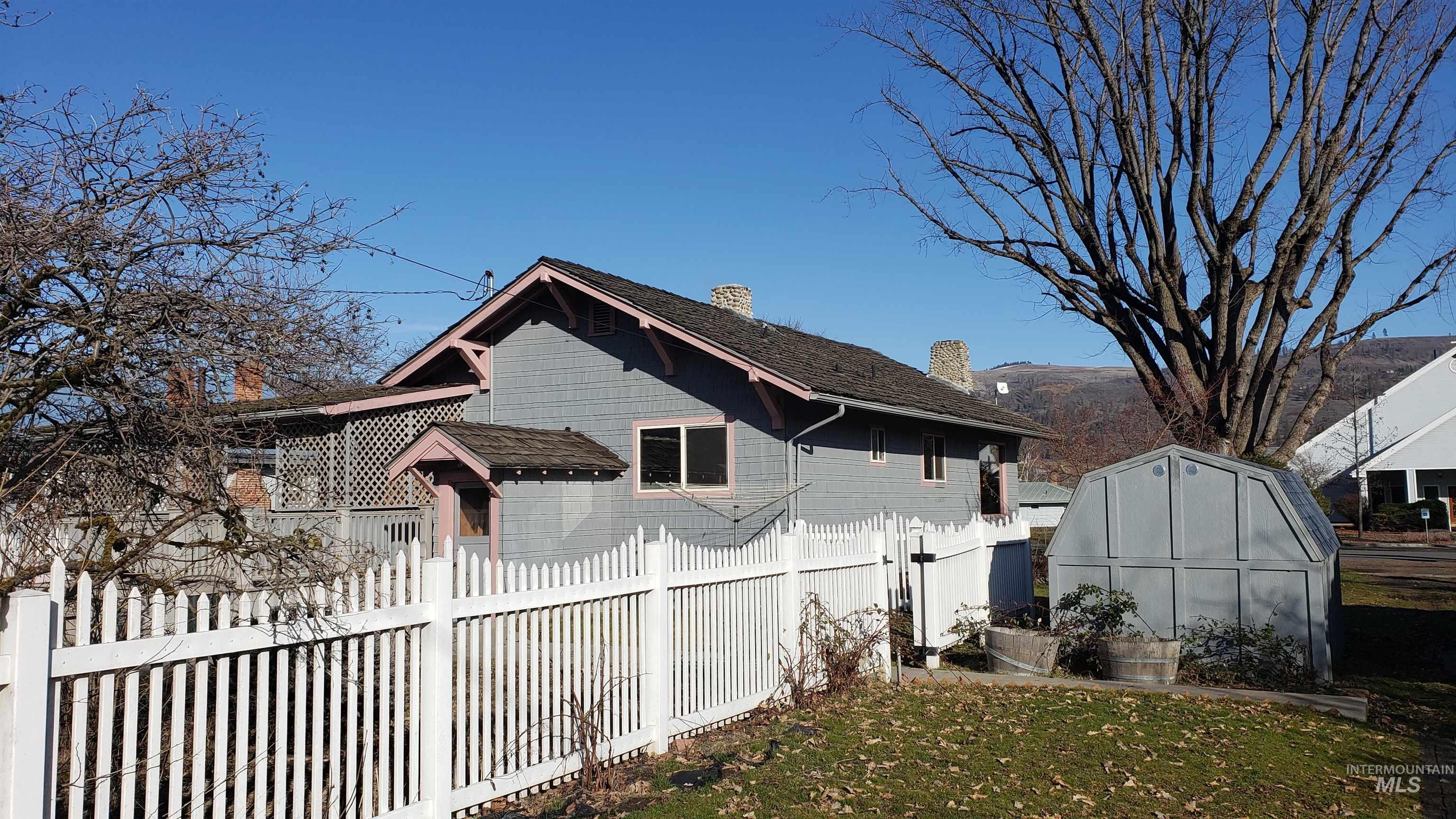 View of side of home featuring a chimney, an outbuilding, and a greenhouse