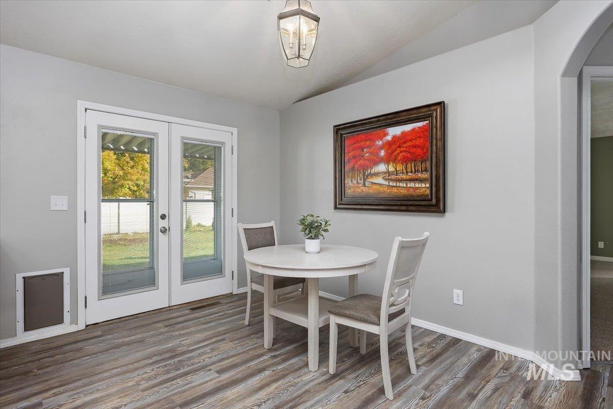 Dining area featuring french doors, wood finished floors, and arched walkways