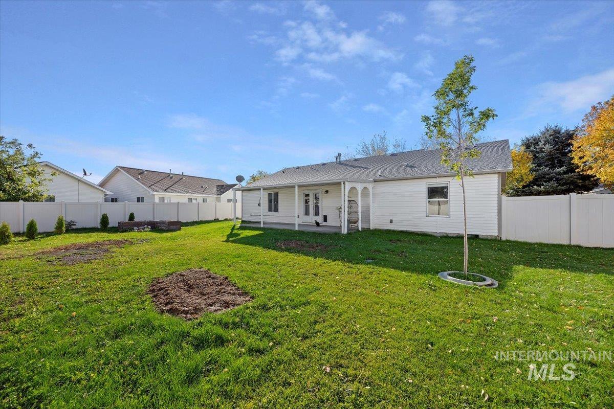 Back of property featuring a fenced backyard and a patio