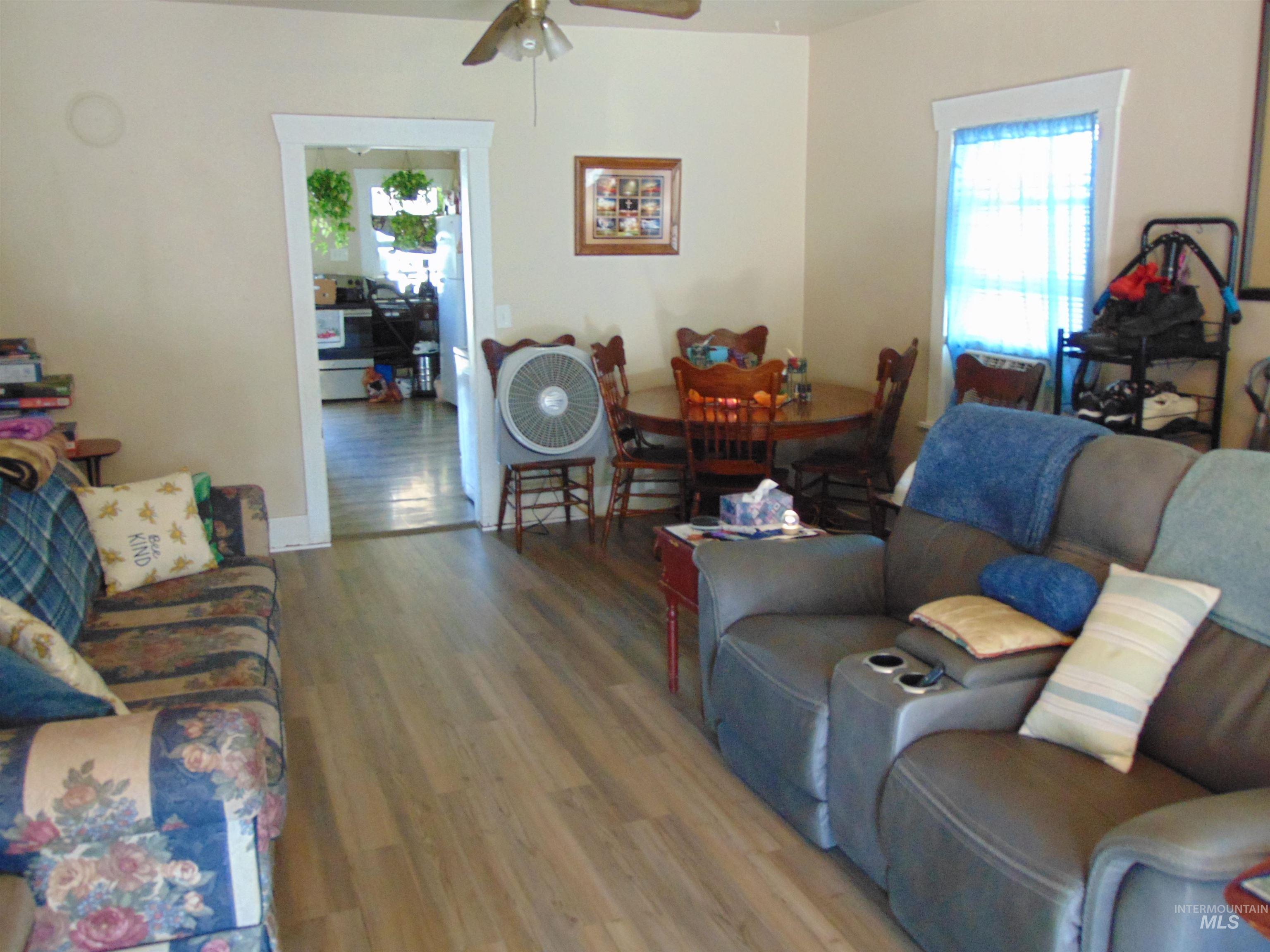 Living area featuring wood finished floors, plenty of natural light, and ceiling fan