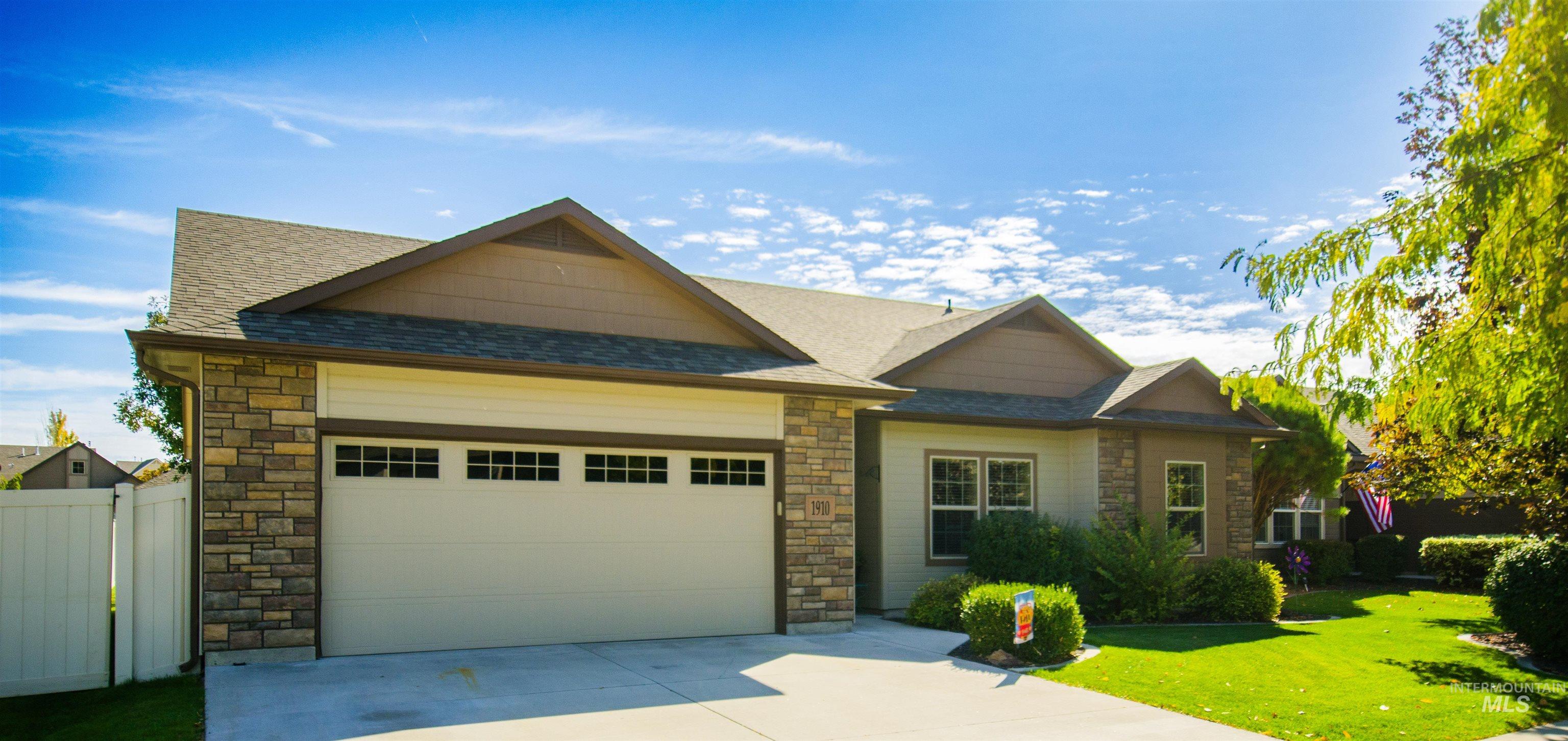Craftsman-style home featuring stone siding, roof with shingles, a garage, and driveway
