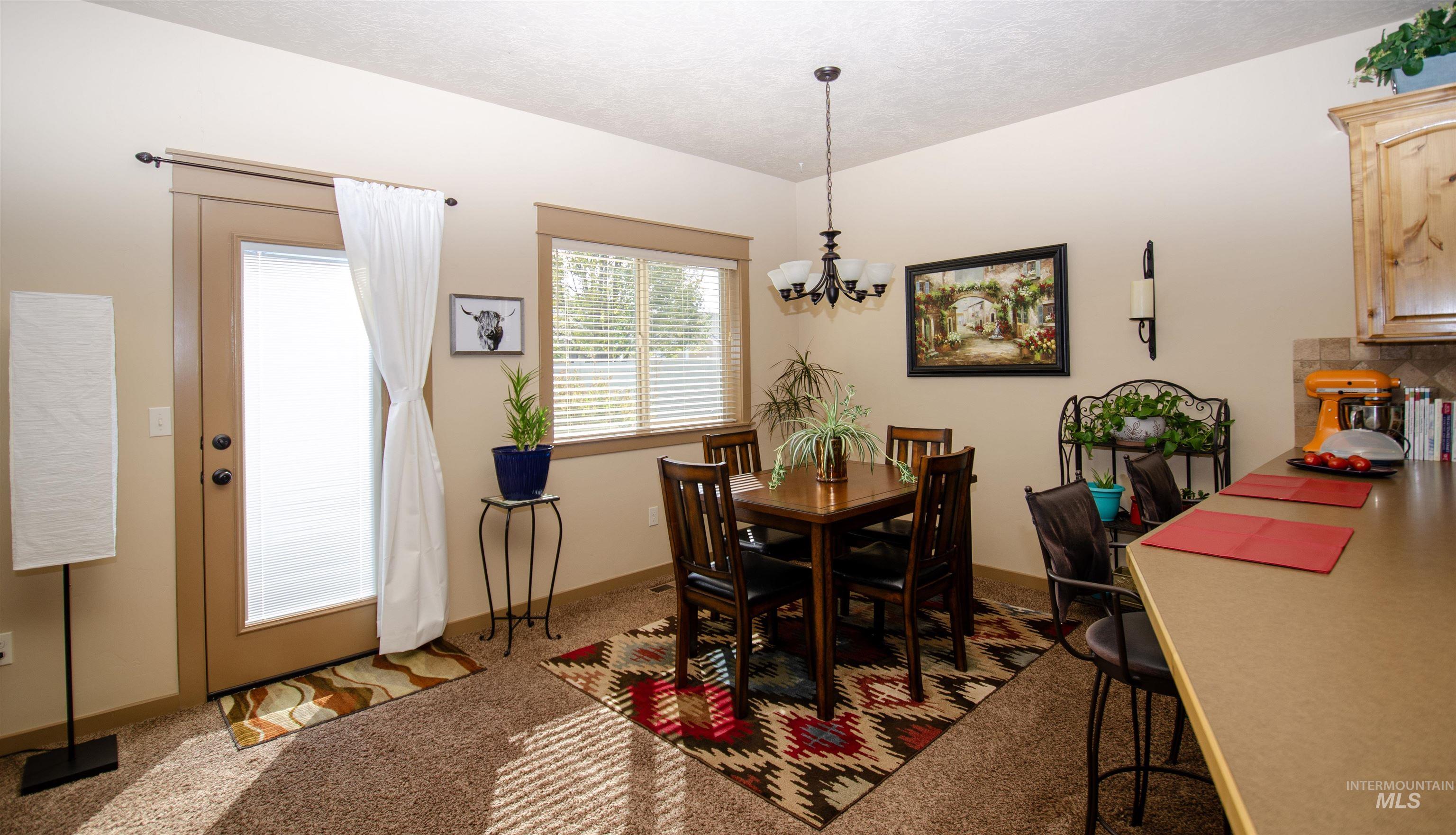 Dining room with light carpet and a chandelier