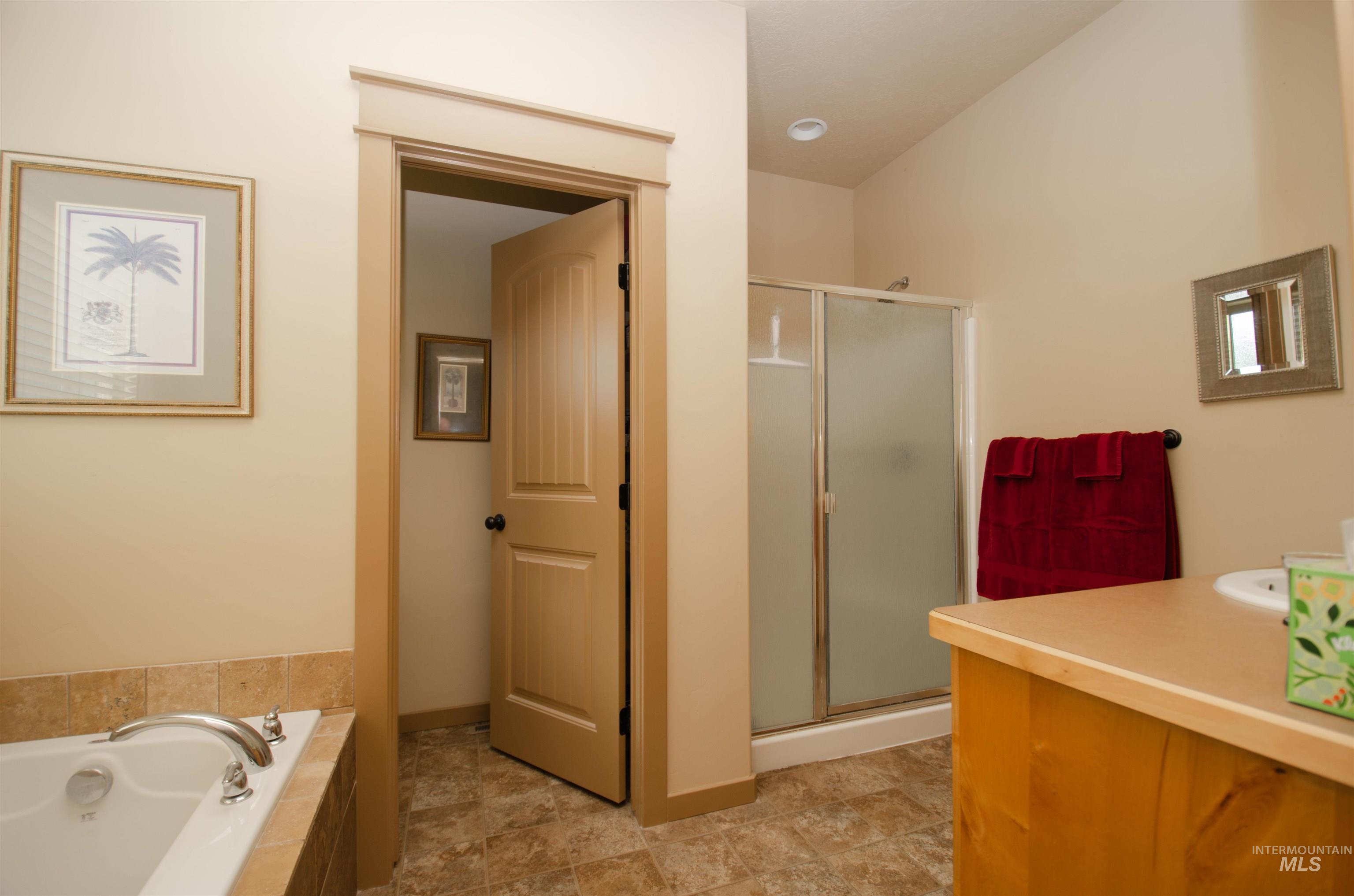 Bathroom with vanity, a bath, and a shower stall