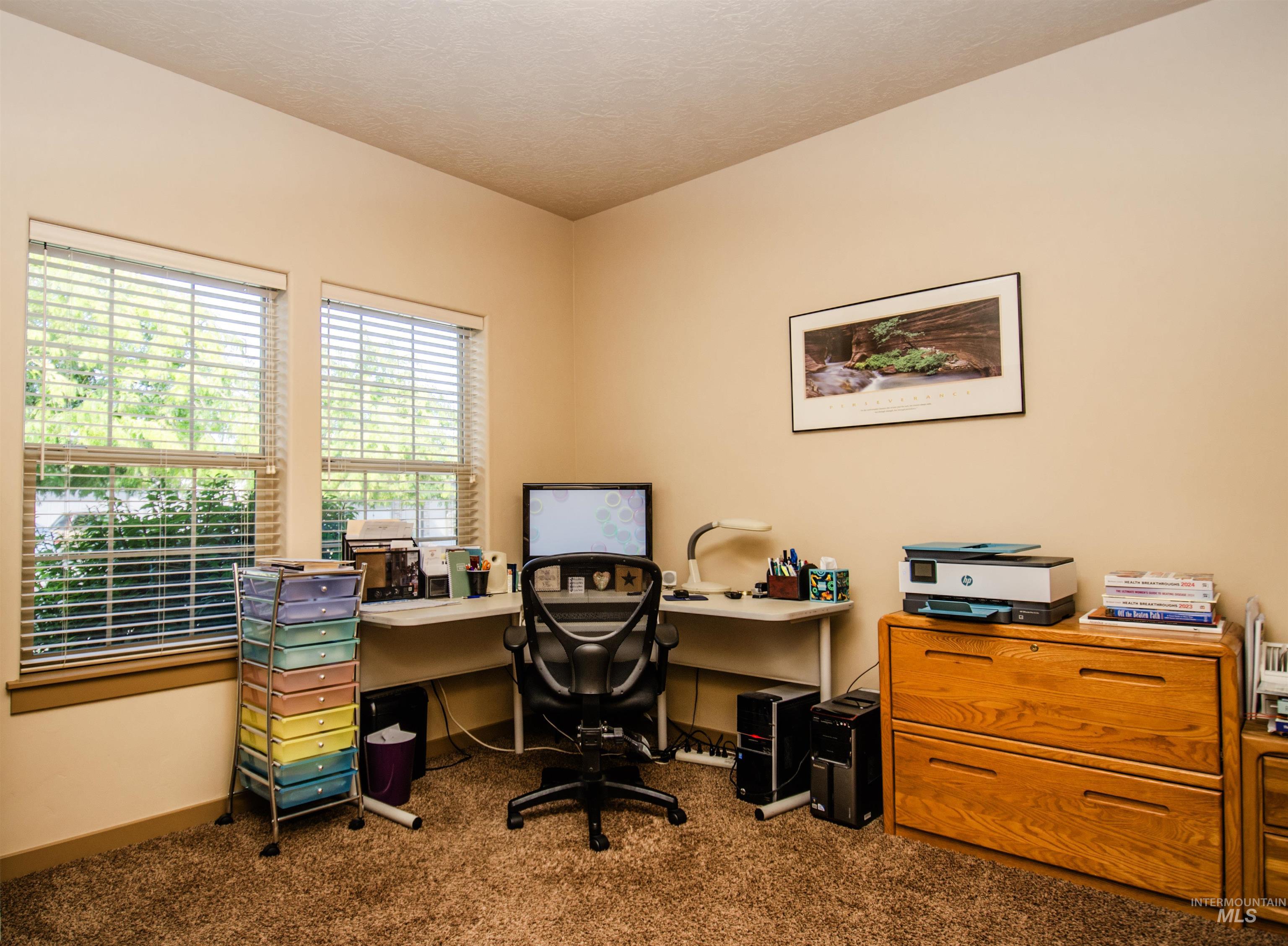 Carpeted office space featuring a textured ceiling