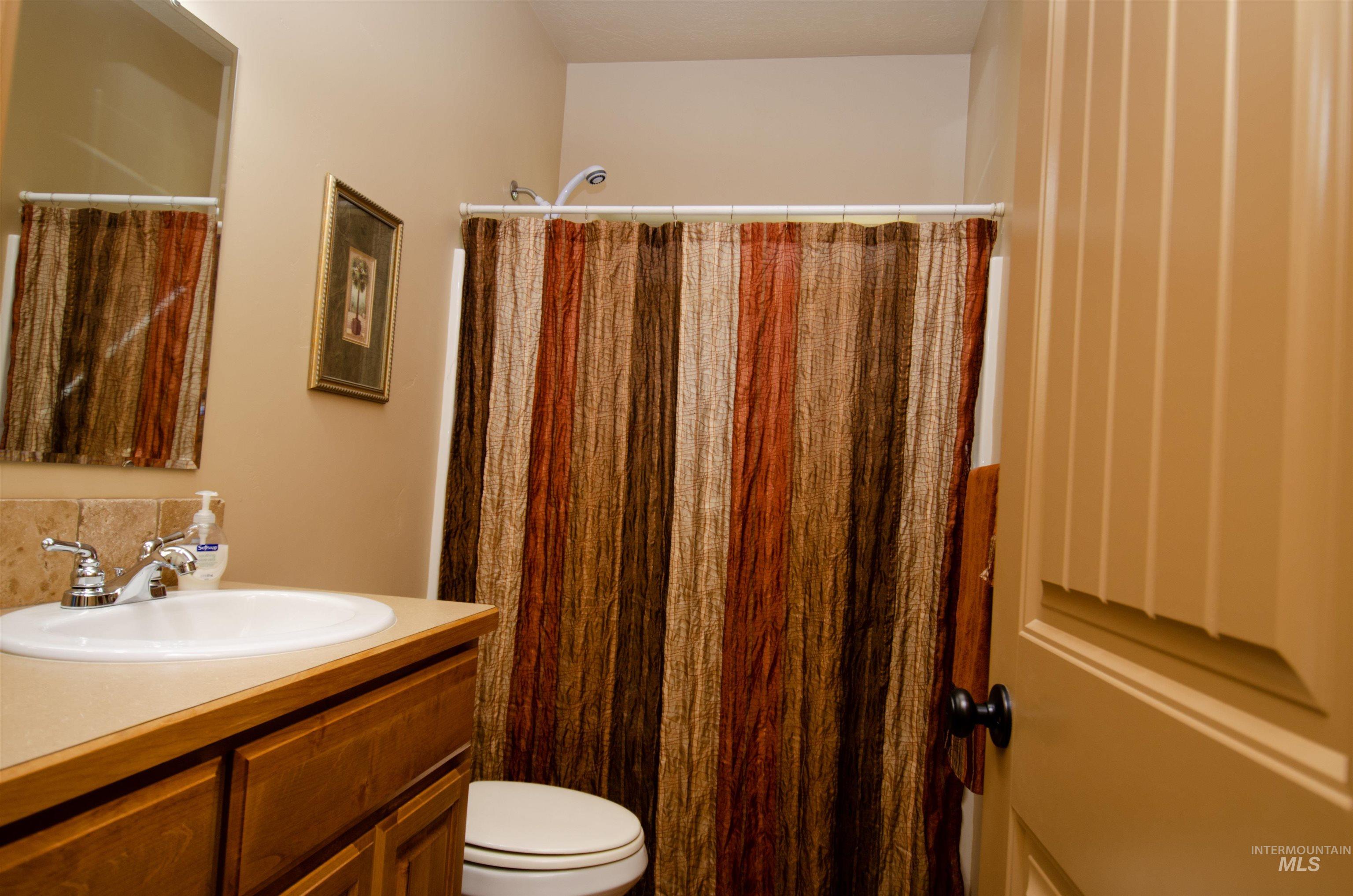 Full bath featuring vanity and curtained shower