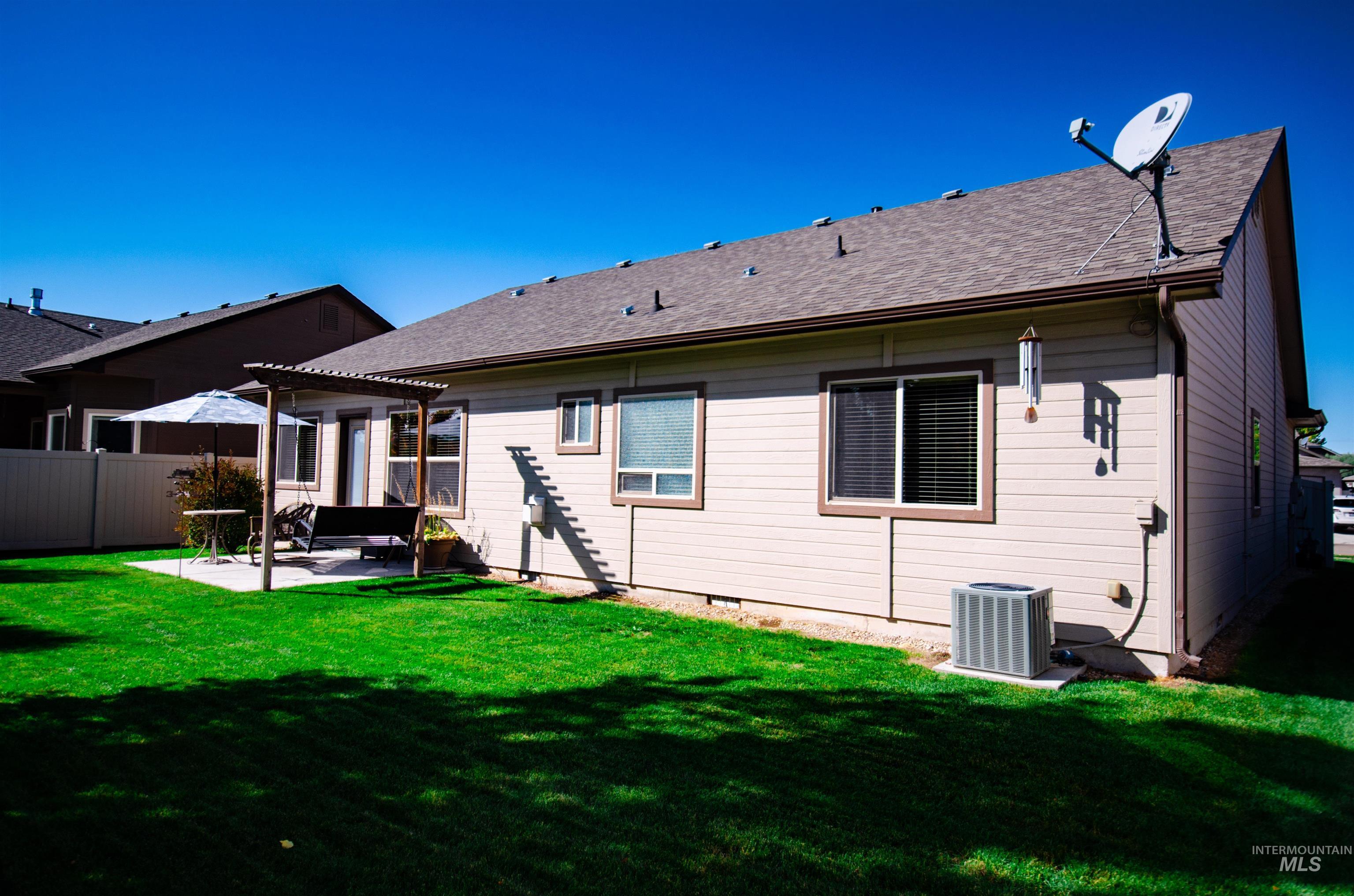 Back of house featuring a patio area, a pergola, and a shingled roof