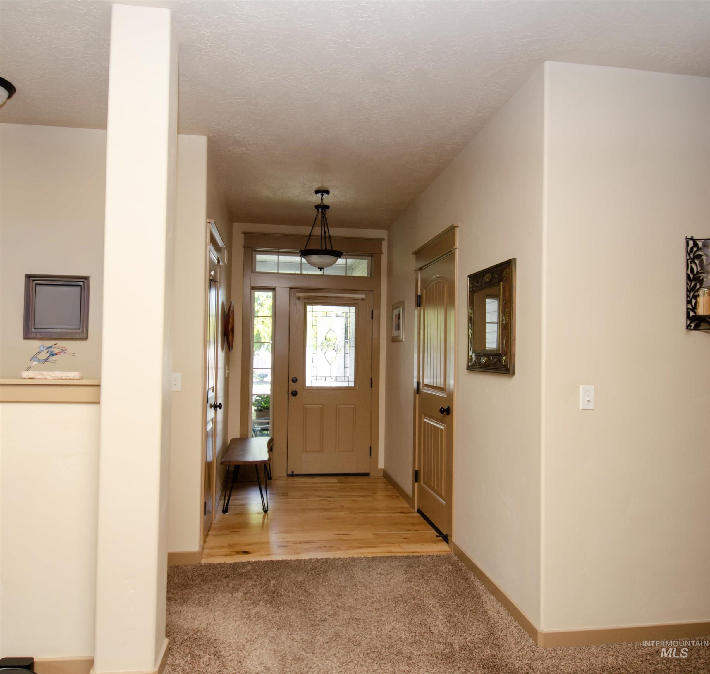 Entrance foyer with light carpet and a textured ceiling