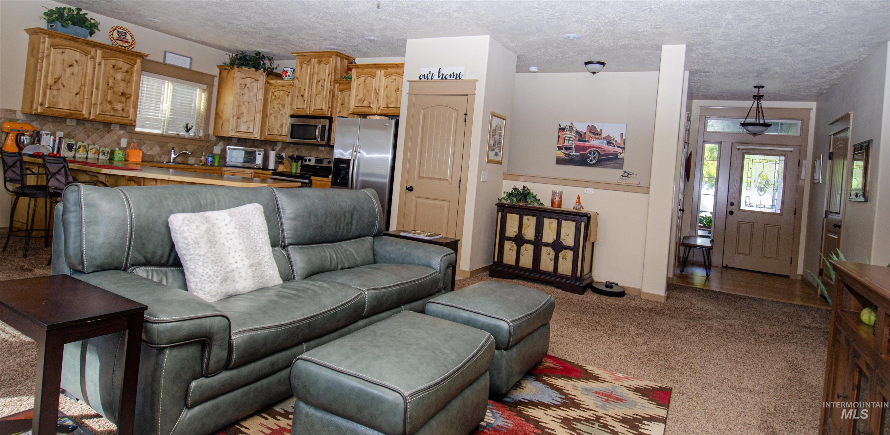 Living room featuring plenty of natural light, light colored carpet, and a textured ceiling