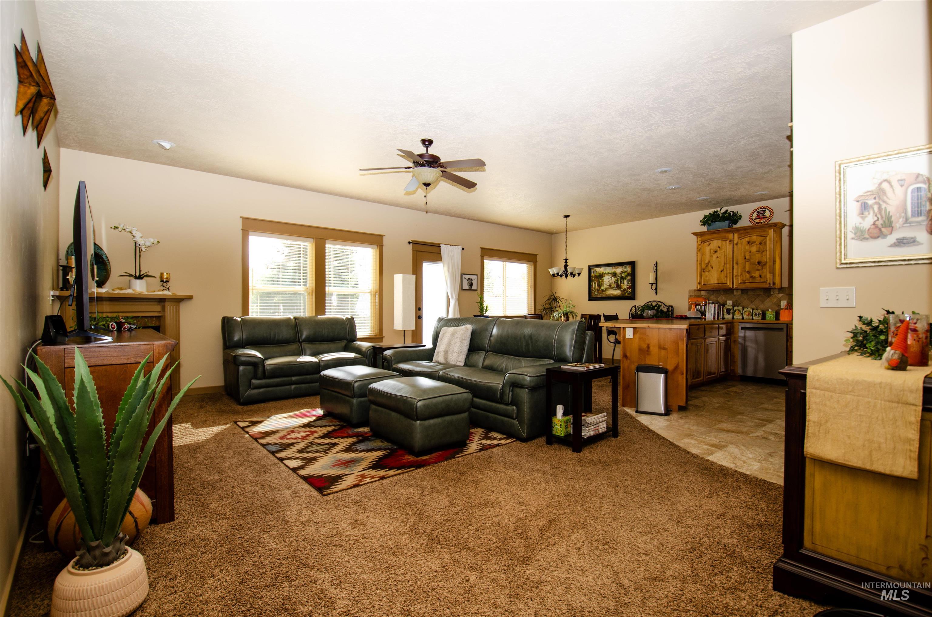 Living area with light colored carpet and ceiling fan