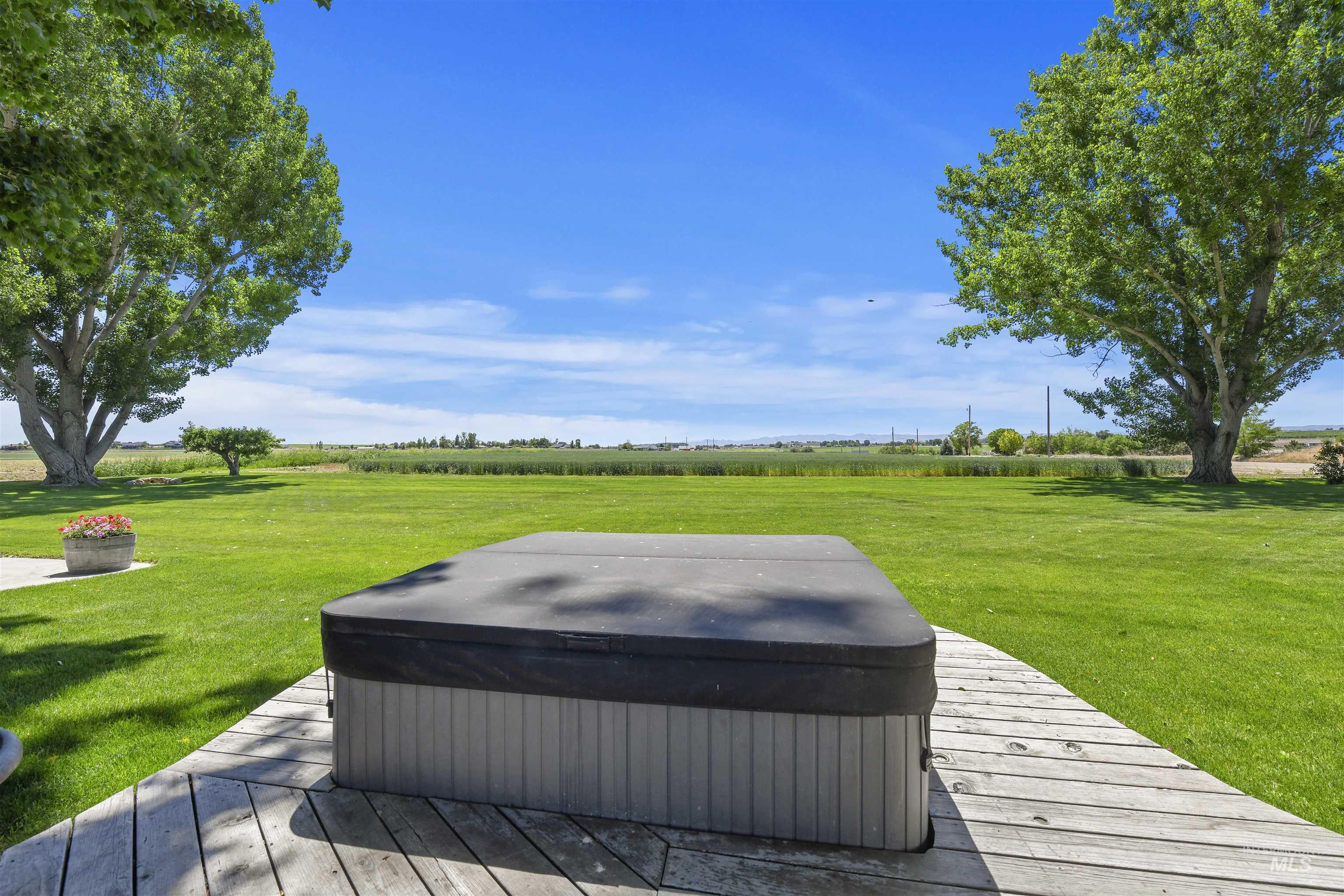 Deck with a yard, a view of rural / pastoral area, and a hot tub