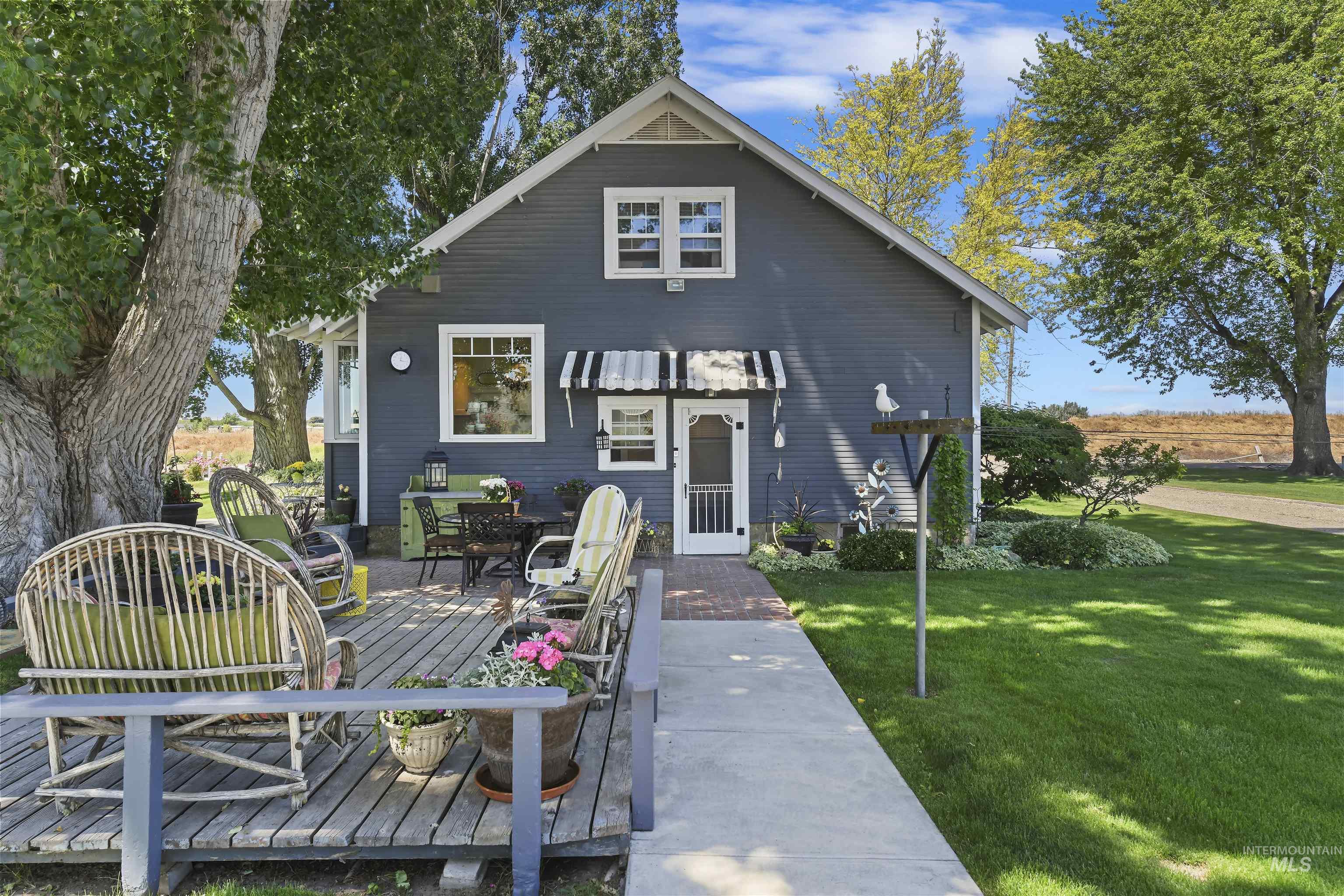 Rear view of property featuring a yard, a wooden deck, and outdoor dining area