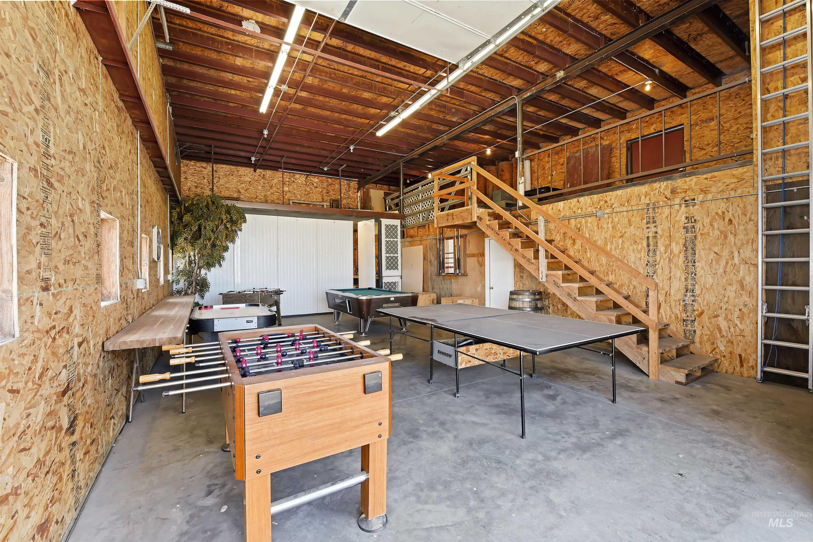 Rec room with unfinished concrete flooring