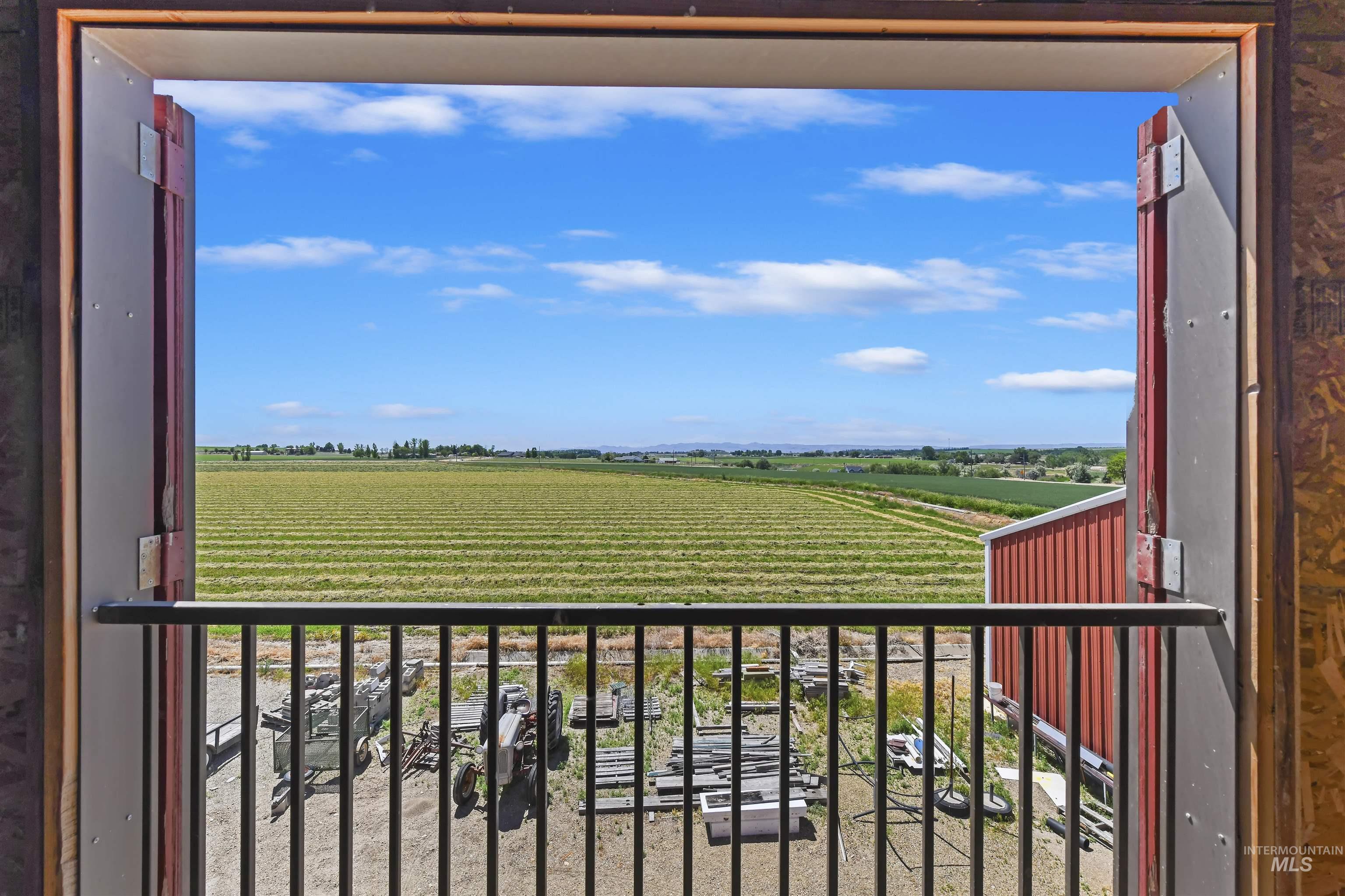 Balcony featuring agricultural area and a rural view