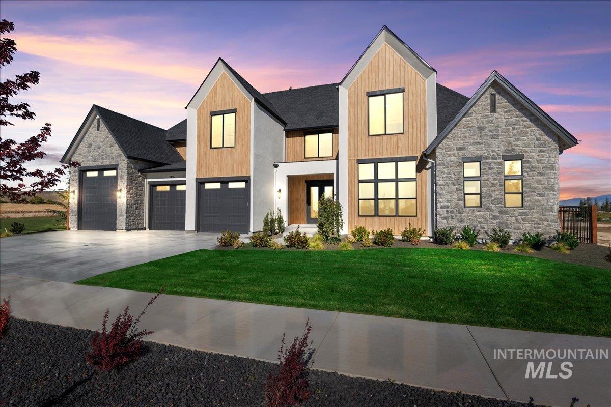 View of front of property featuring stone siding and concrete driveway