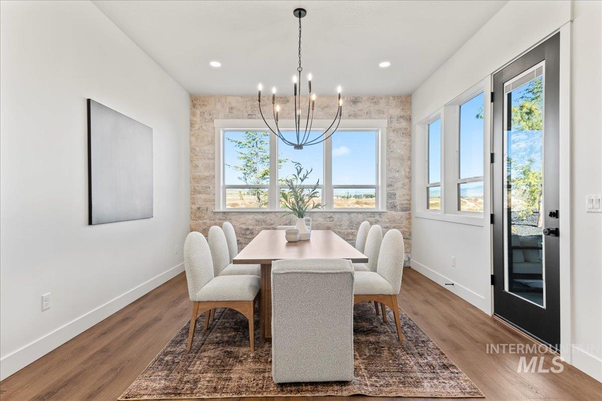 Dining room with a chandelier, dark wood finished floors, and plenty of natural light