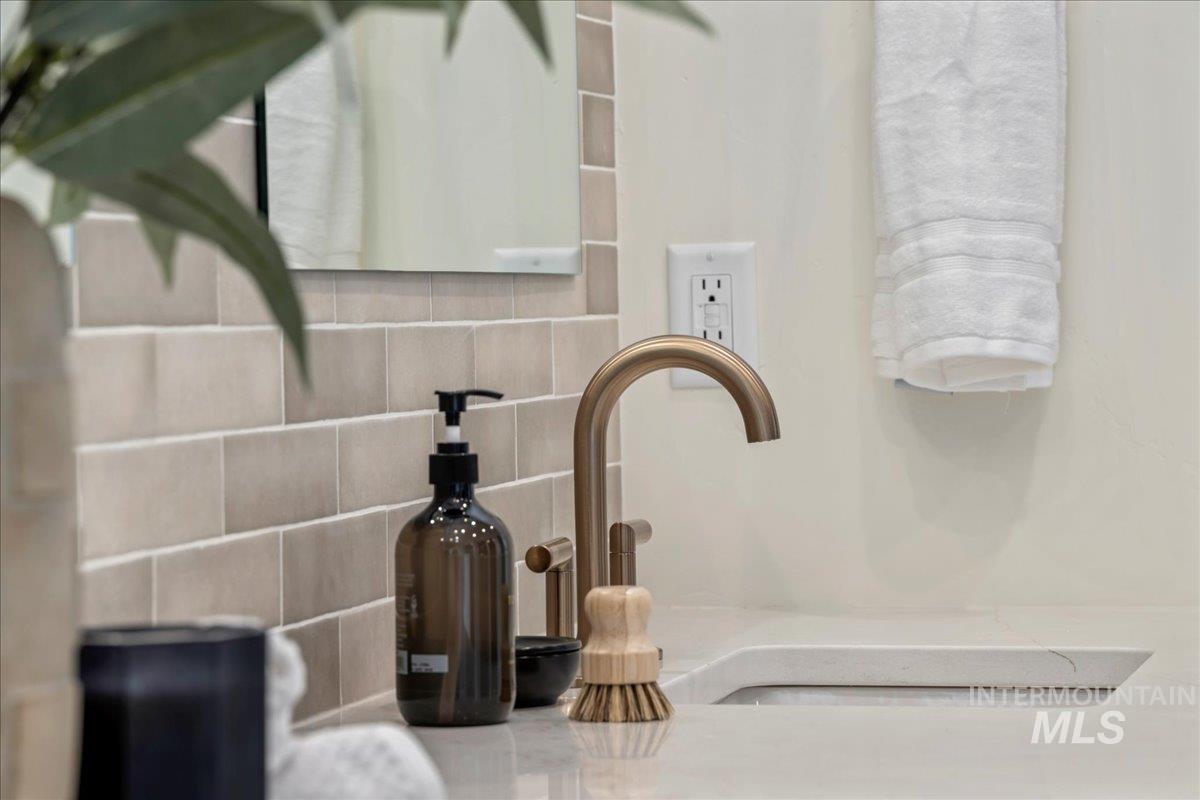 Bathroom view of decorative backsplash and a sink