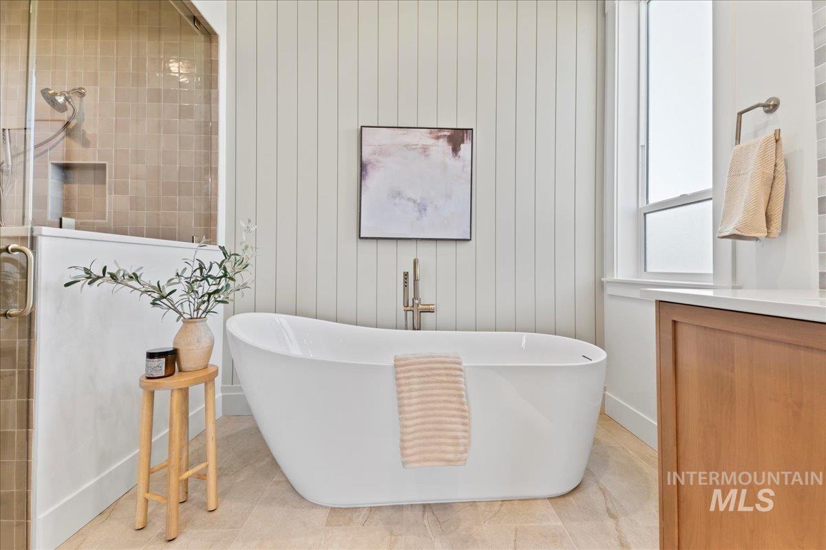 Full bathroom with a tile shower, a freestanding tub, and tile patterned flooring