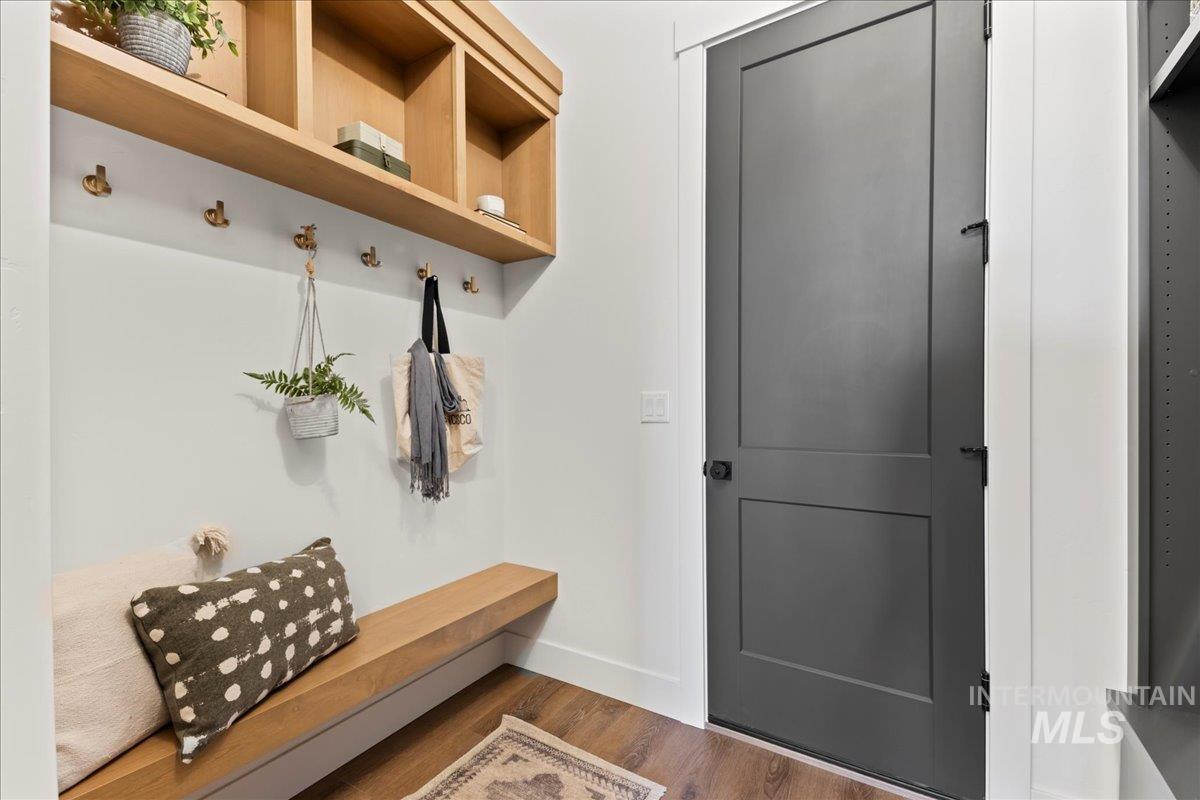 Mudroom with dark wood finished floors and coat hooks