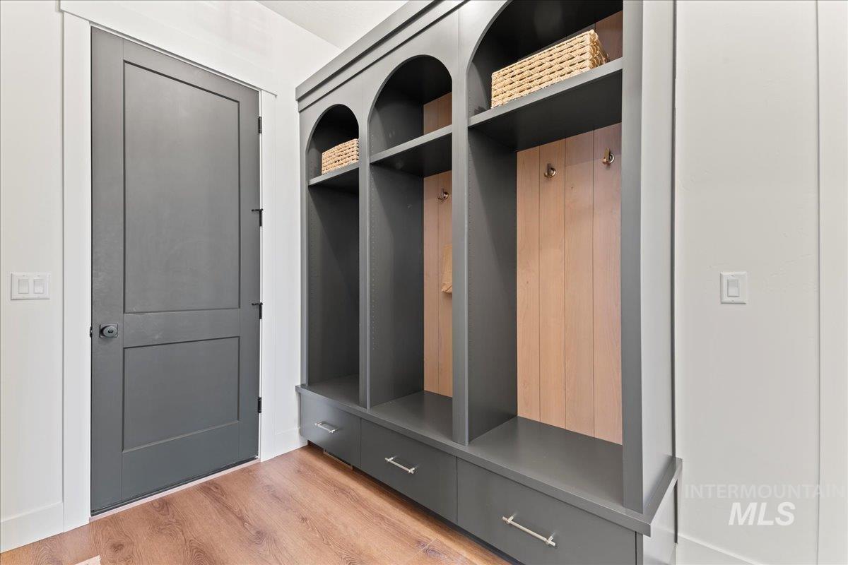 Mudroom with wood finished floors and custom cubbys