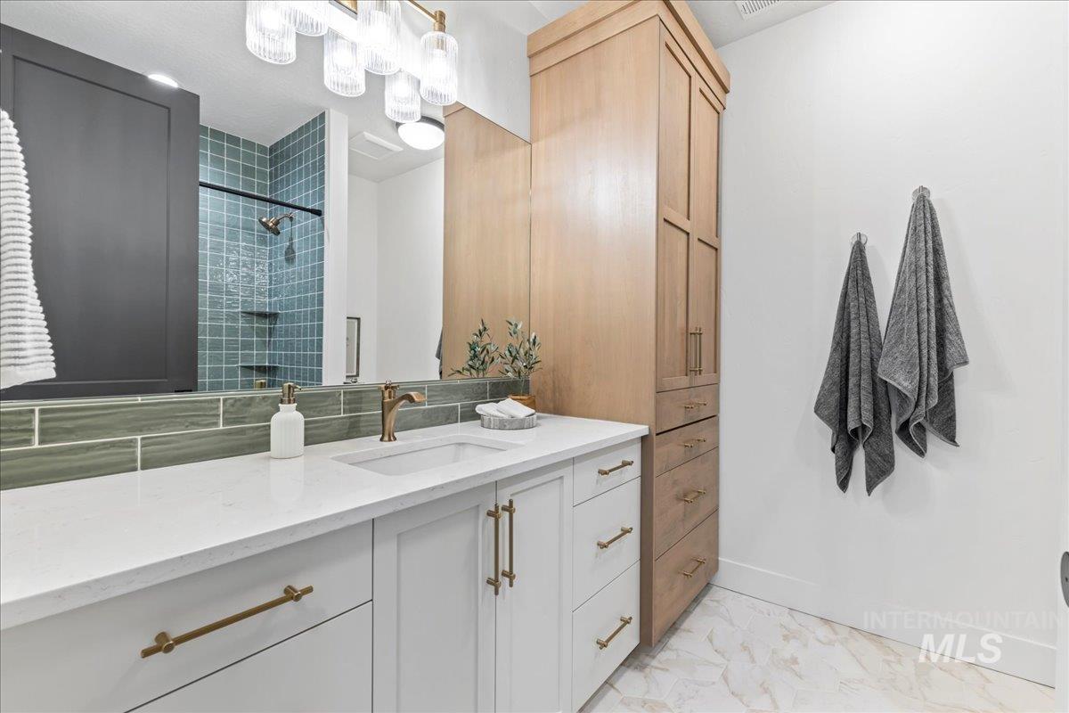 Full bathroom featuring vanity and tiled shower