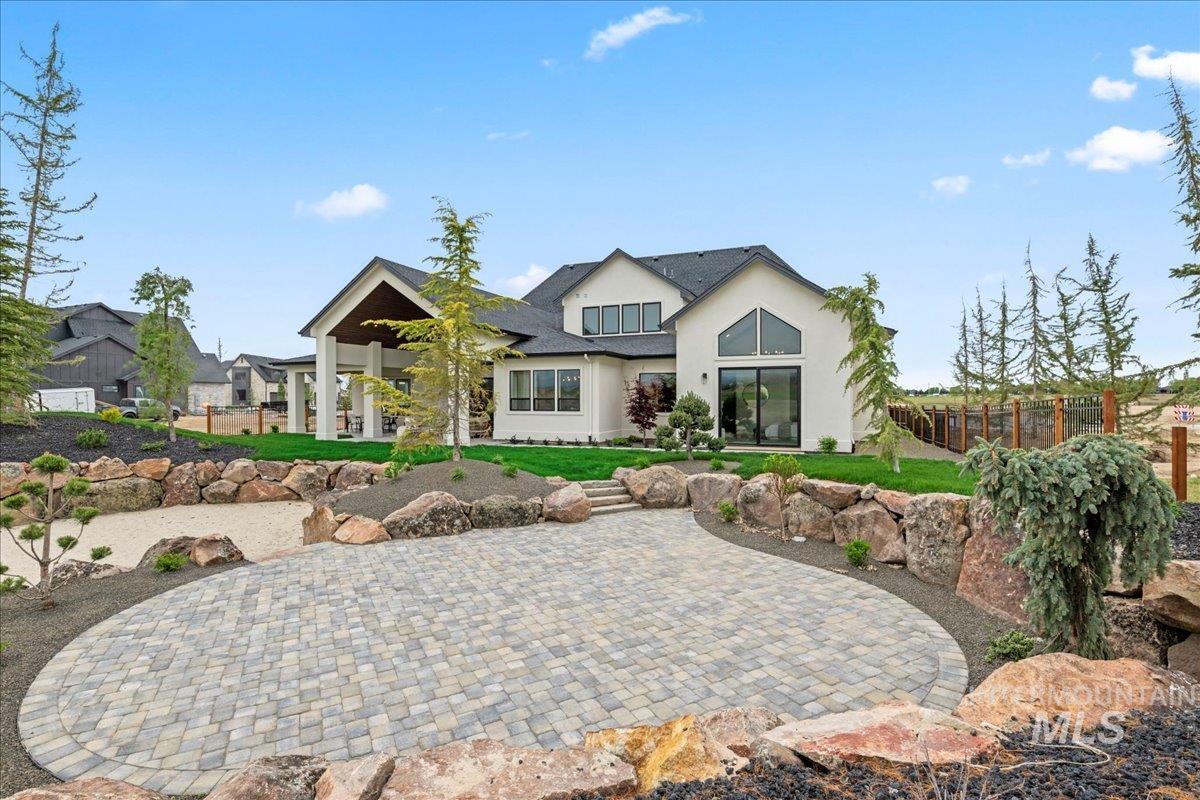 Back of property featuring a paver patio and stucco siding