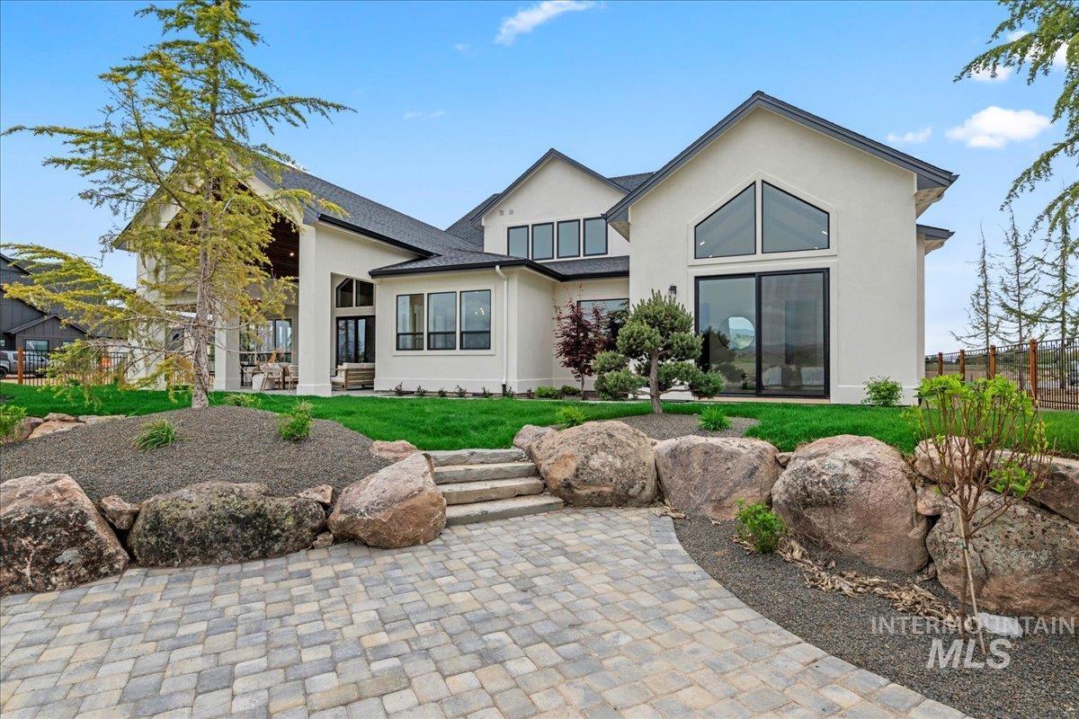 Back of property with a yard, stucco siding, and a paver patio