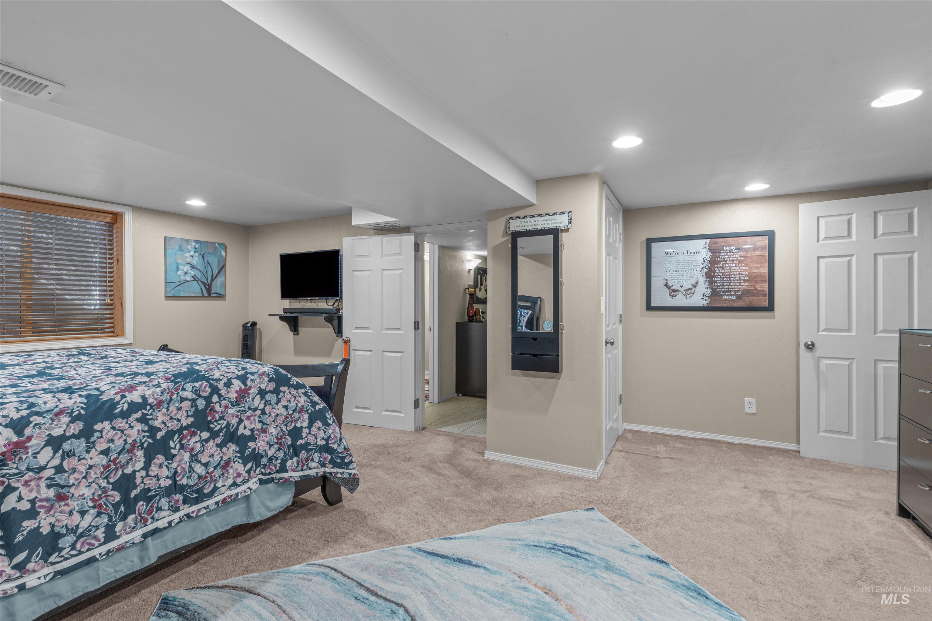 Bedroom with light colored carpet and recessed lighting