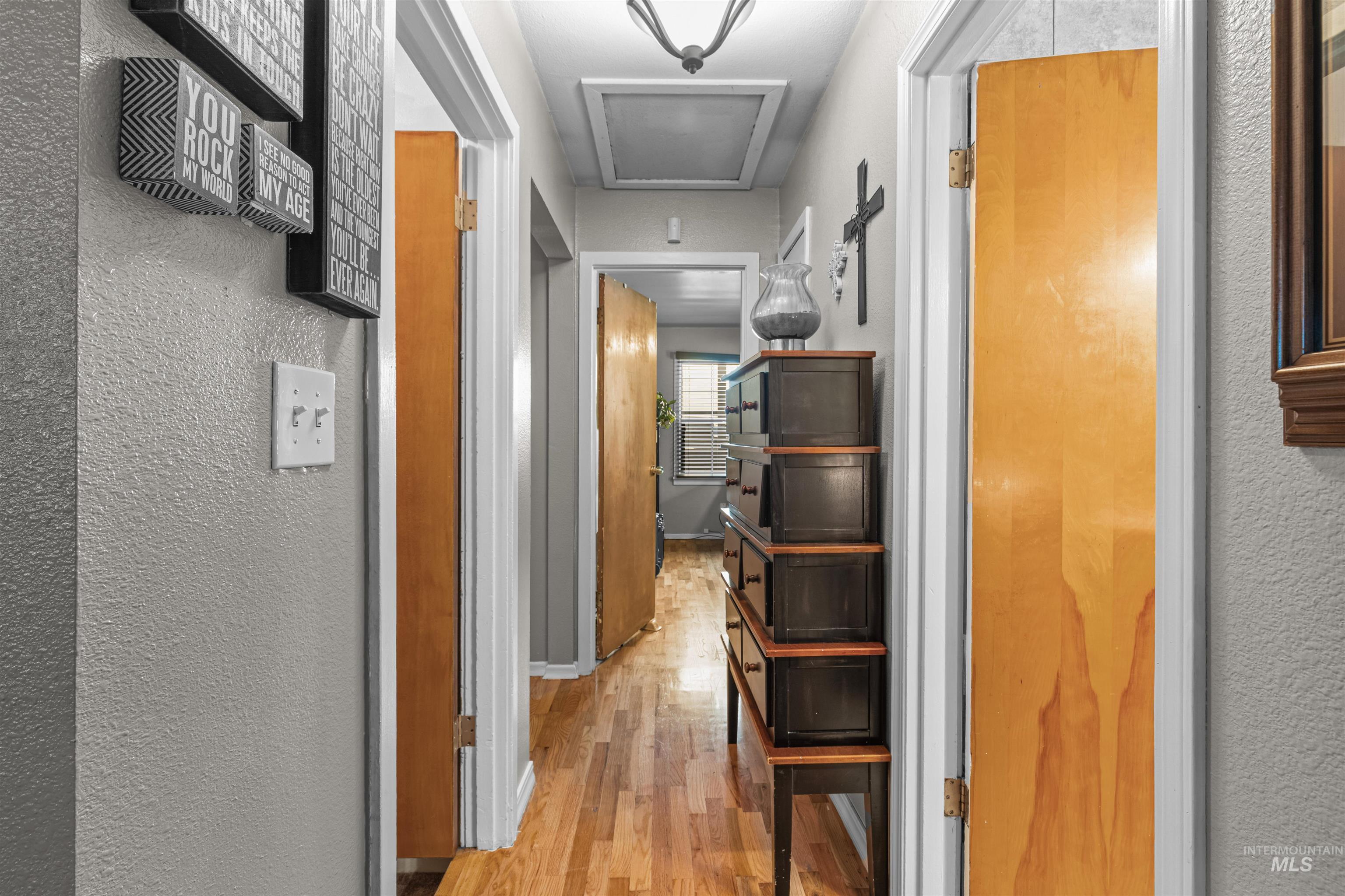 Corridor featuring a textured wall and light wood finished floors