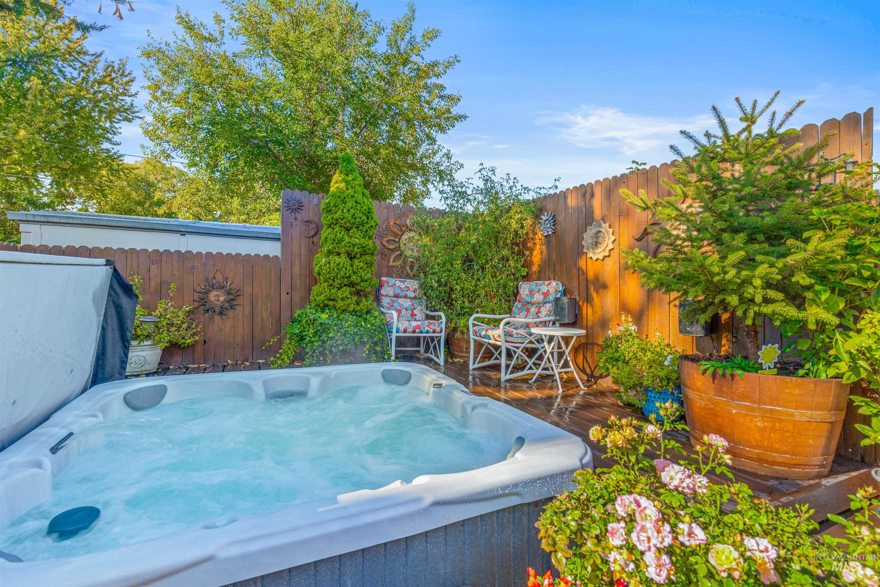 Fenced backyard with a hot tub and a deck