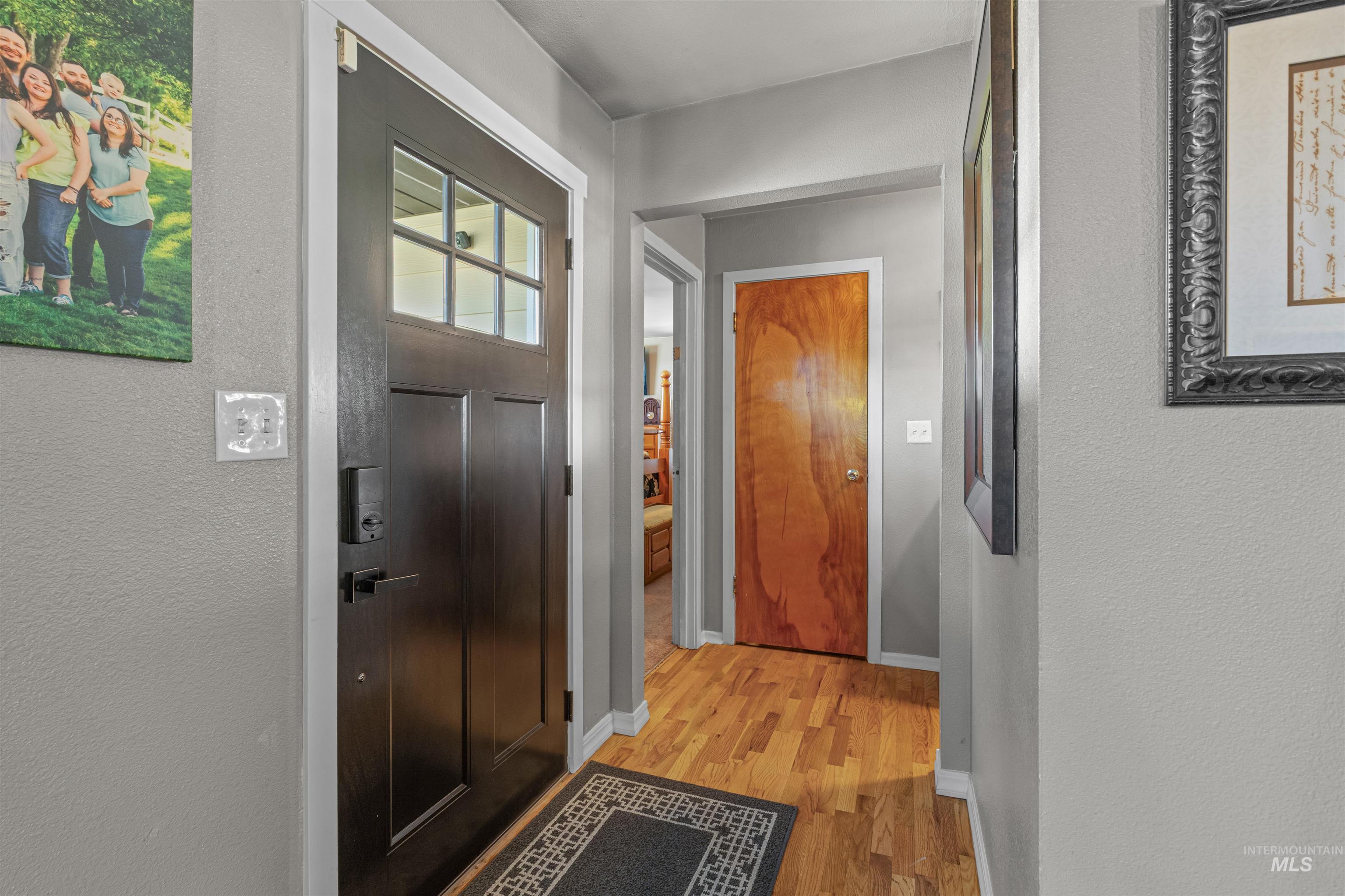 Doorway to outside with wood finished floors and a textured wall