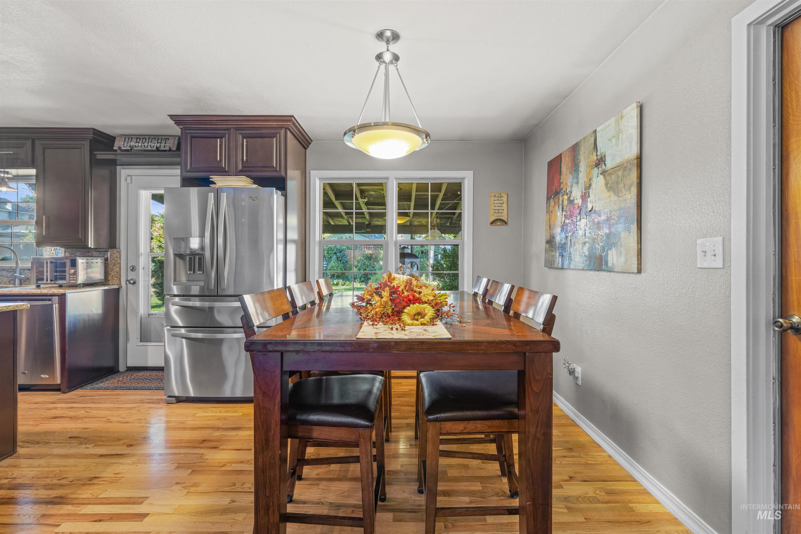 Dining room with light wood finished floors and a textured wall