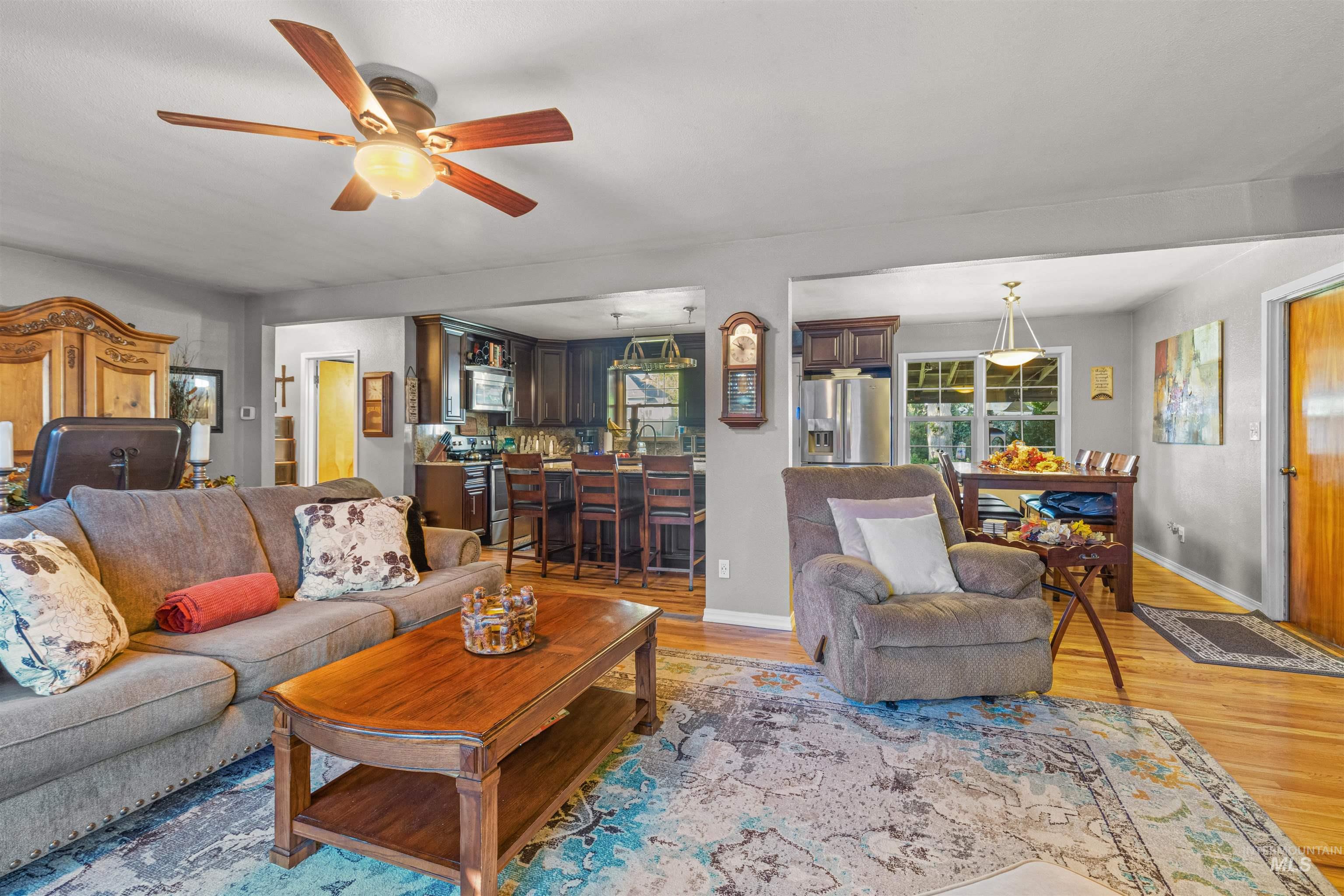 Living area featuring light wood-style floors and ceiling fan