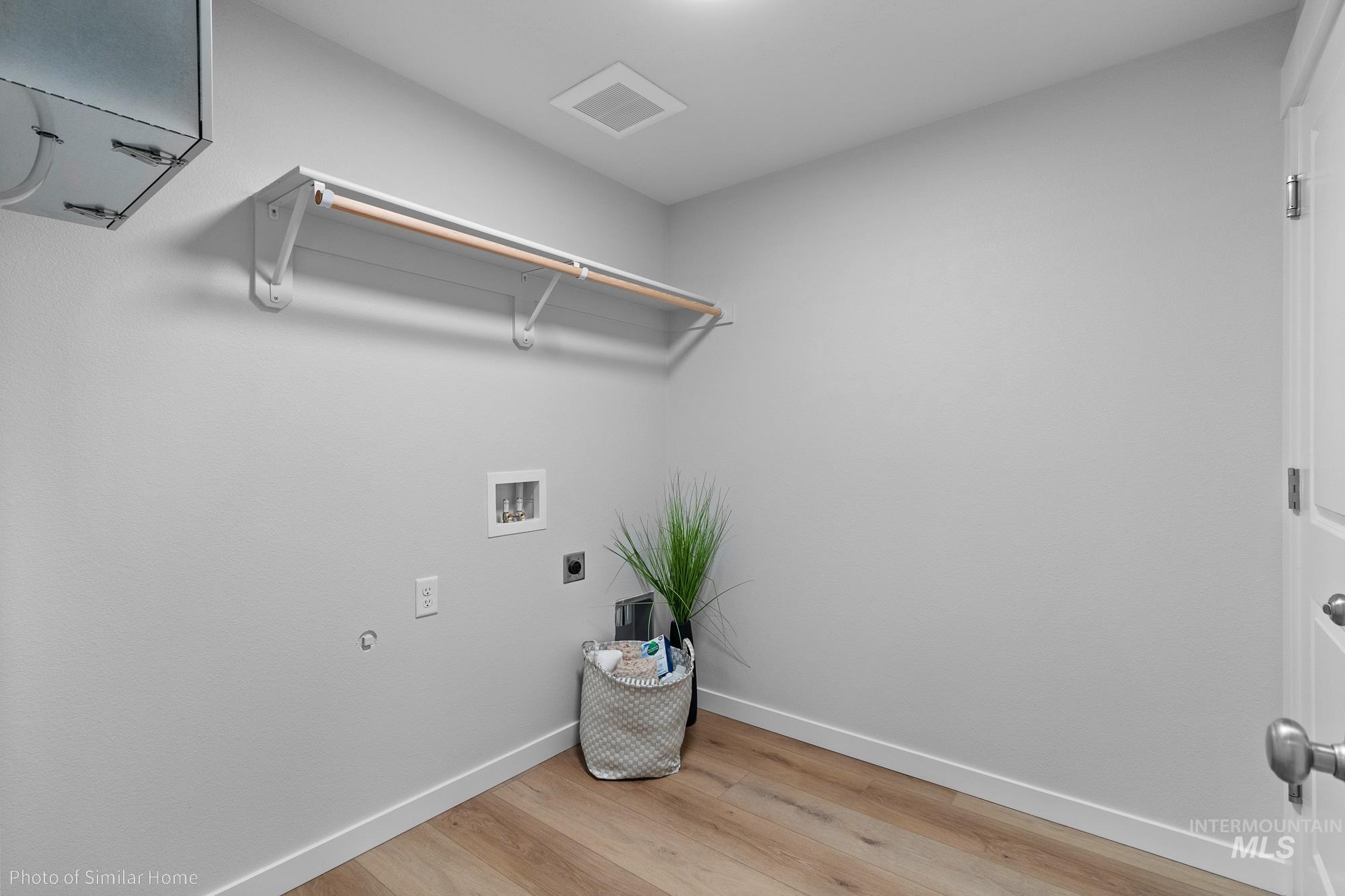 Laundry room with light wood-type flooring, hookup for an electric dryer, and washer hookup