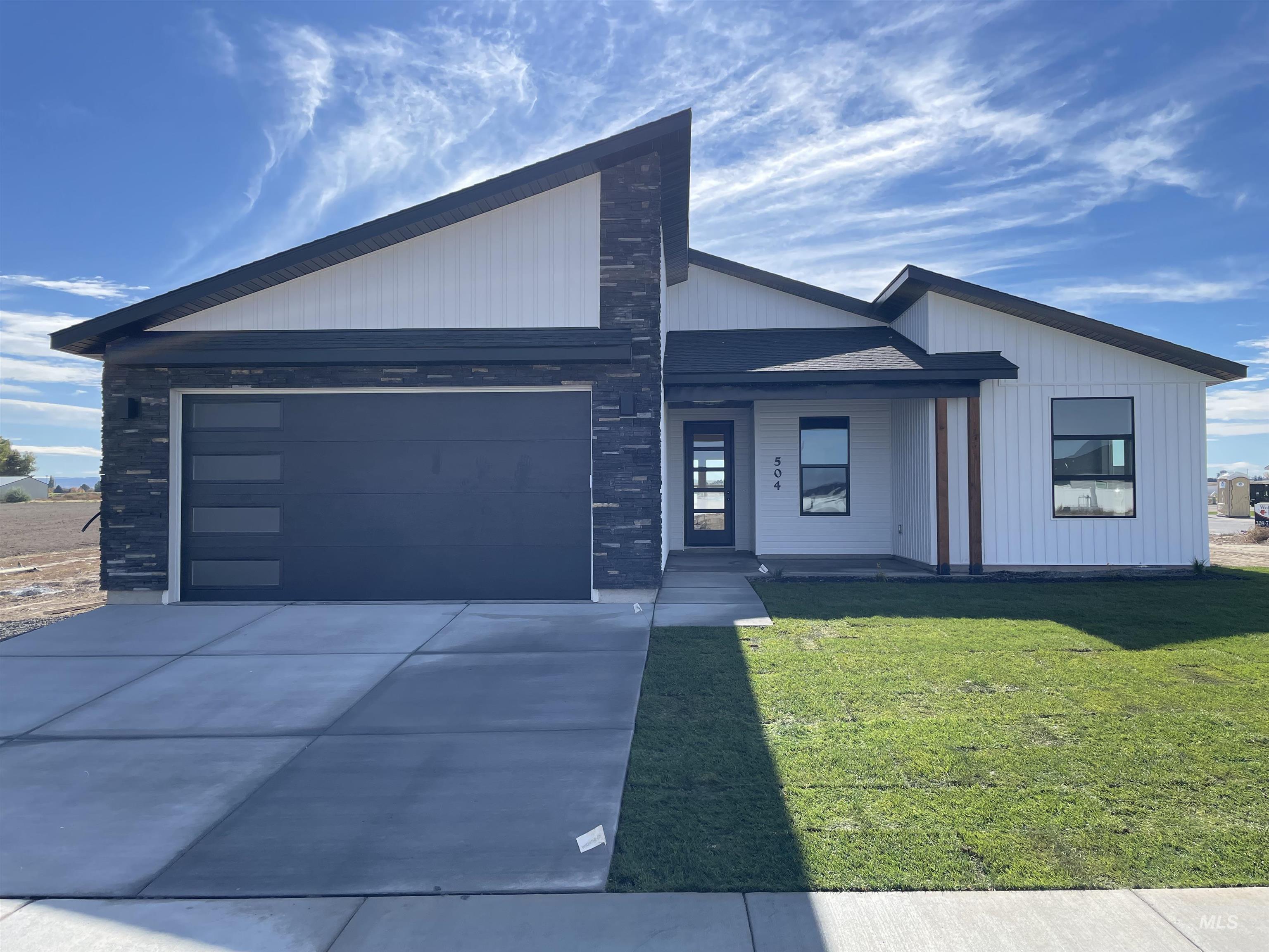View of front of property with a front lawn, a porch, driveway, and an attached garage
