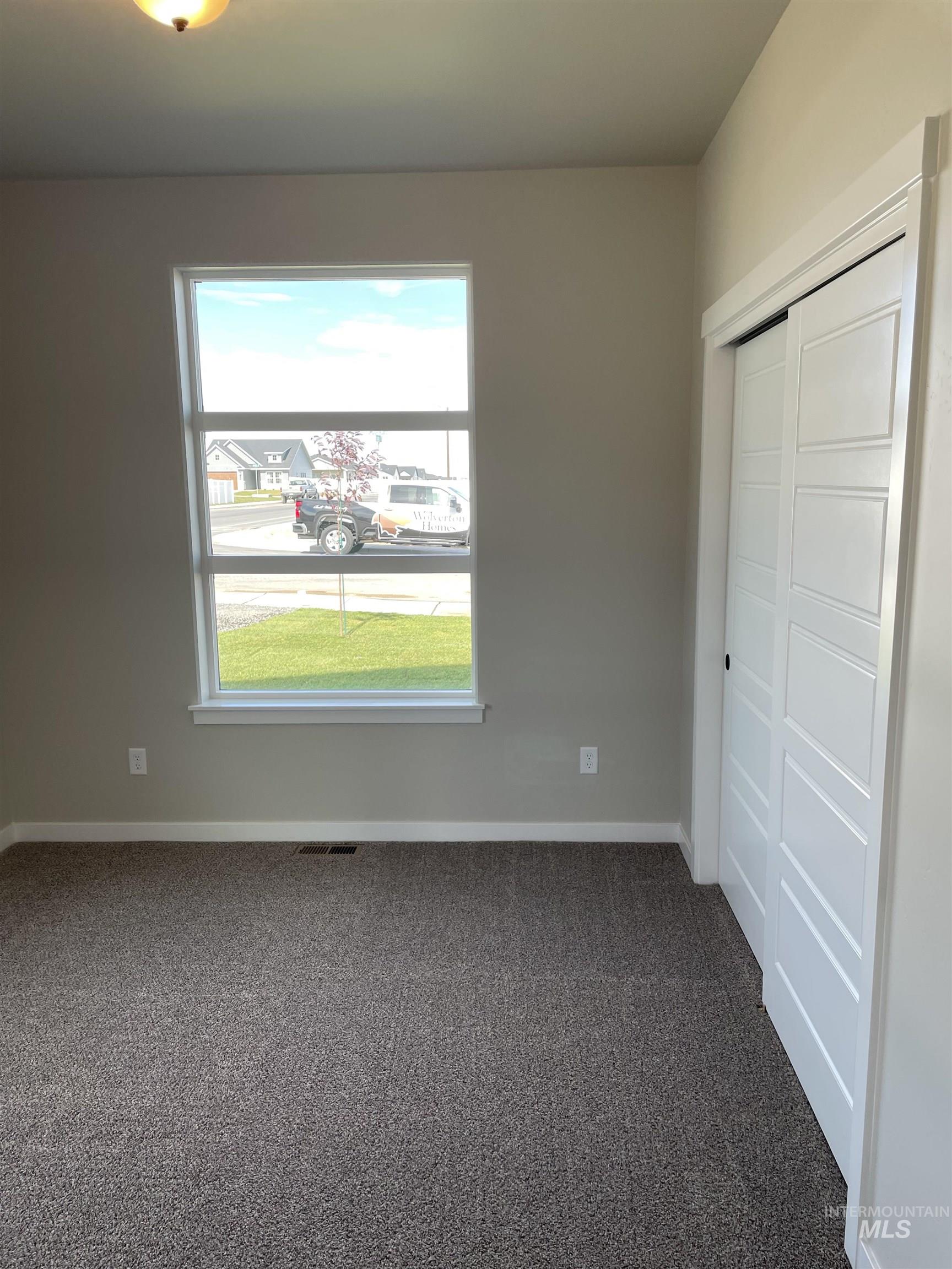 Unfurnished bedroom with dark colored carpet and a closet