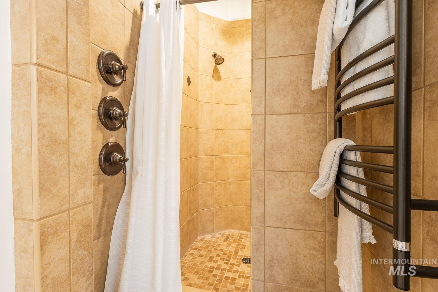 Full bathroom featuring a stall shower and a towel warming rack