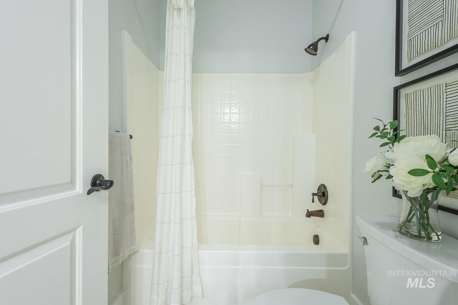 Bathroom with toilet and shower / bathtub combination with curtain