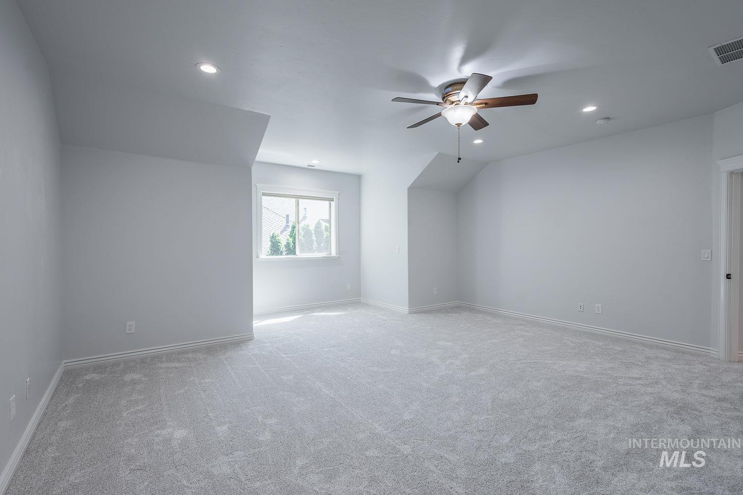 Additional living space featuring light colored carpet, a ceiling fan, recessed lighting, and lofted ceiling