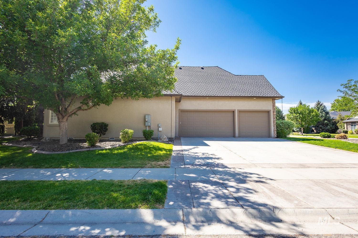 View of front facade with stucco siding, concrete driveway, an attached garage, and a front yard