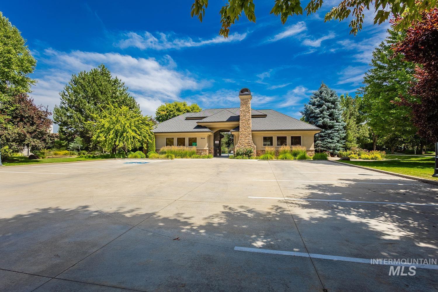 View of front of house featuring a chimney, solar panels, and uncovered parking