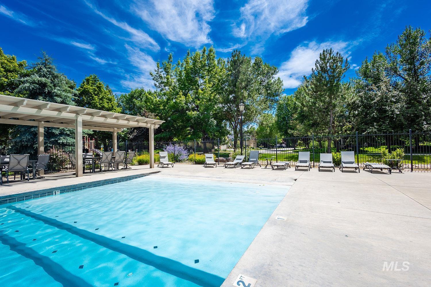 Community pool featuring a pergola and a patio