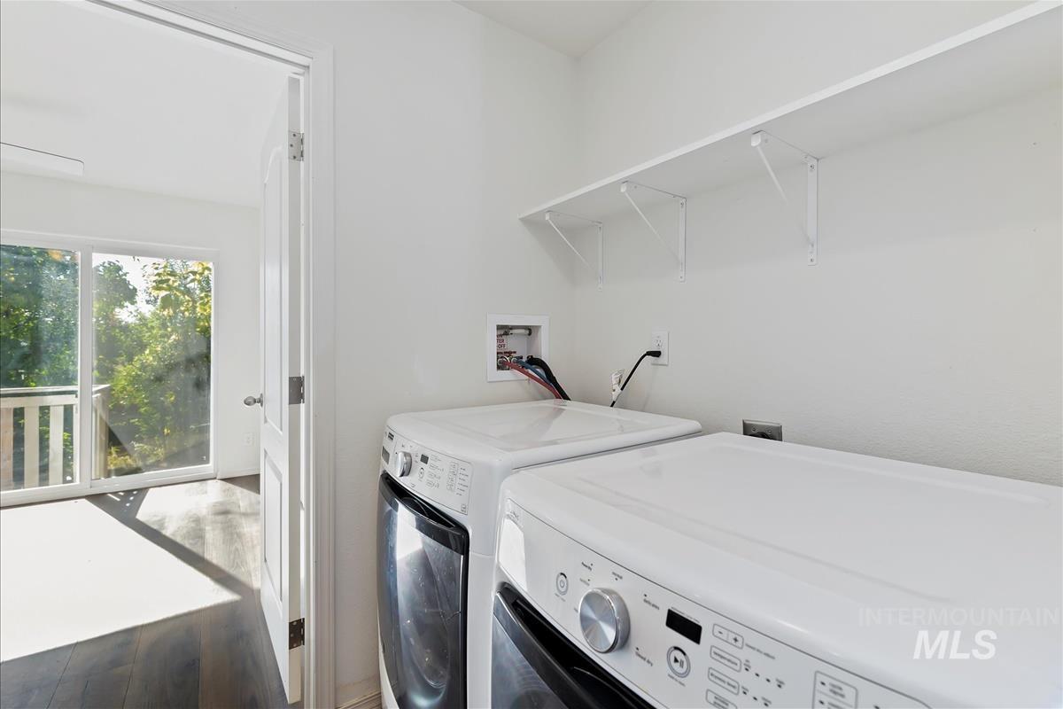 Laundry area featuring wood finished floors and separate washer and dryer