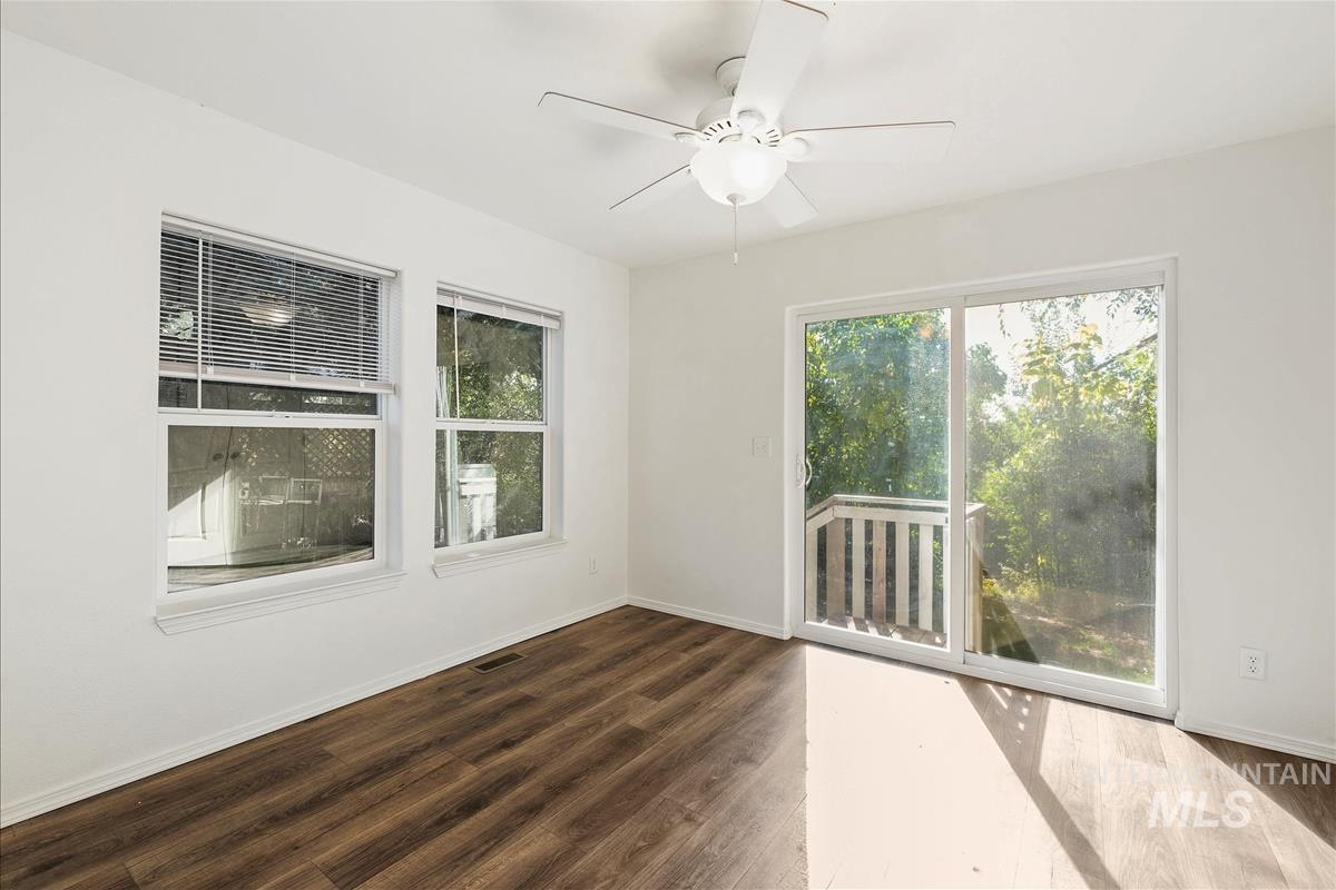 Unfurnished room featuring dark wood finished floors and a ceiling fan