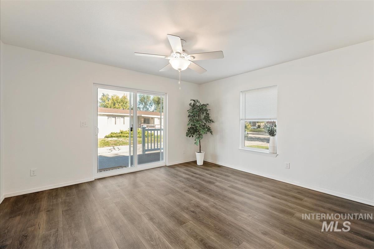 Unfurnished room with dark wood finished floors and a ceiling fan