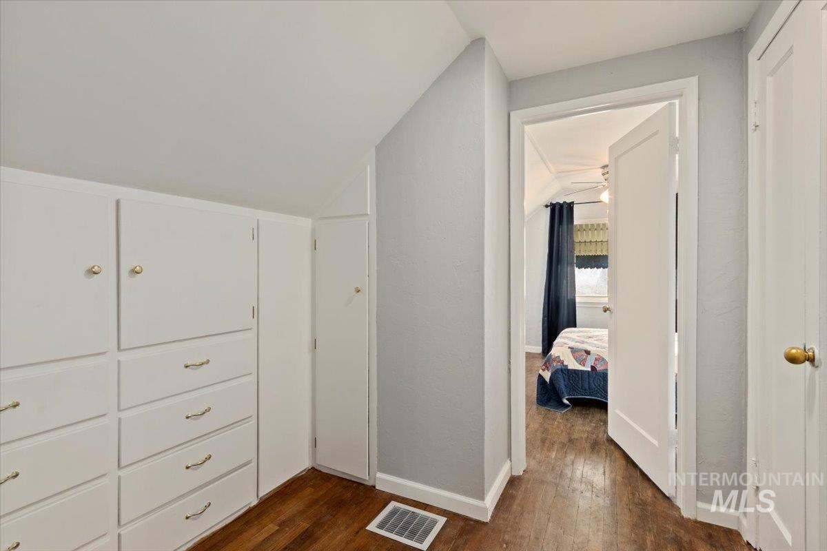 Spacious closet with dark wood finished floors and vaulted ceiling