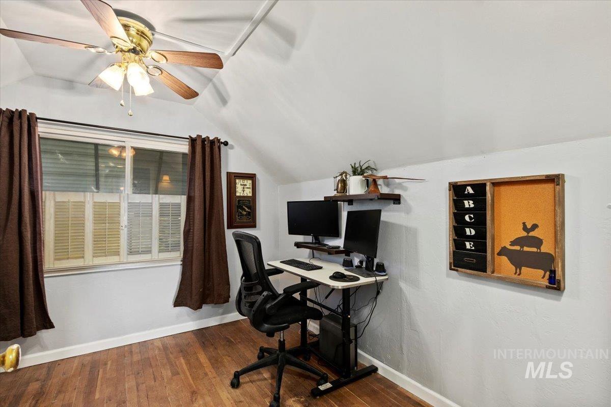 Office area with lofted ceiling, dark wood-type flooring, and ceiling fan
